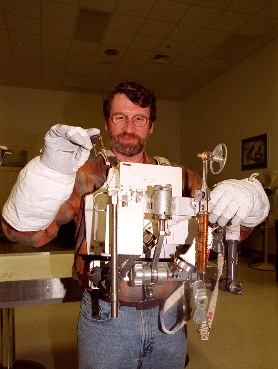 KENNEDY SPACE CENTER, FLA. --  While on a tour of KSC, Norm Abram, master carpenter of television’s "This Old House" and "The New Yankee Workshop," tries on a tool carrier and some of the tools used in space. Abram is at the Center to film an episode of "This Old House.