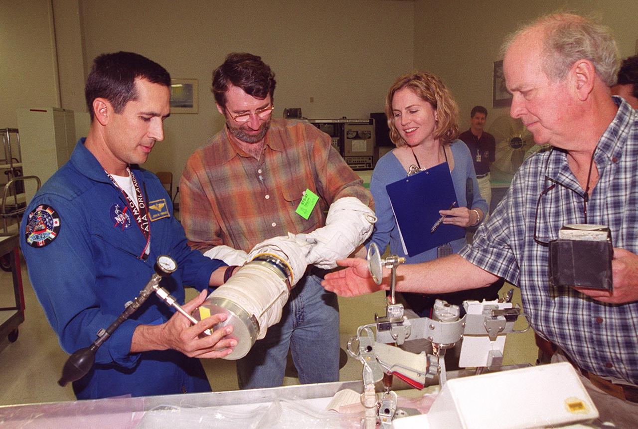KENNEDY SPACE CENTER, FLA. --  Astronaut John Herrington (left) shows tools and equipment used in space to Norm Abram, master carpenter of television’s "This Old House" and "The New Yankee Workshop."  At right are two of the film crew with Abram. Abram is at KSC to film an episode of "This Old House.