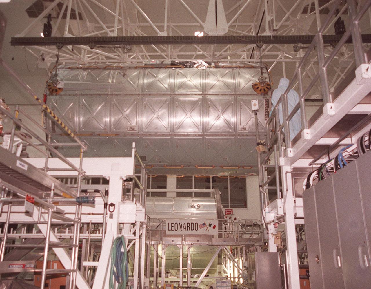 KENNEDY SPACE CENTER, FLA. -- In its overhead passage down the Space Station Processing Facility, the U.S. Laboratory Destiny travels past the Multi-Purpose Logistics Module Leonardo. Both are elements in the construction of the International Space Station. The lab is being moved to the Launch Package Integration Stand (LPIS) for a weight and center of gravity determination. Destiny is the payload aboard Space Shuttle Atlantis on mission STS-98 to the Space Station. The lab is fitted with five system racks and will already have experiments installed inside for the flight. The launch is scheduled for January 2001