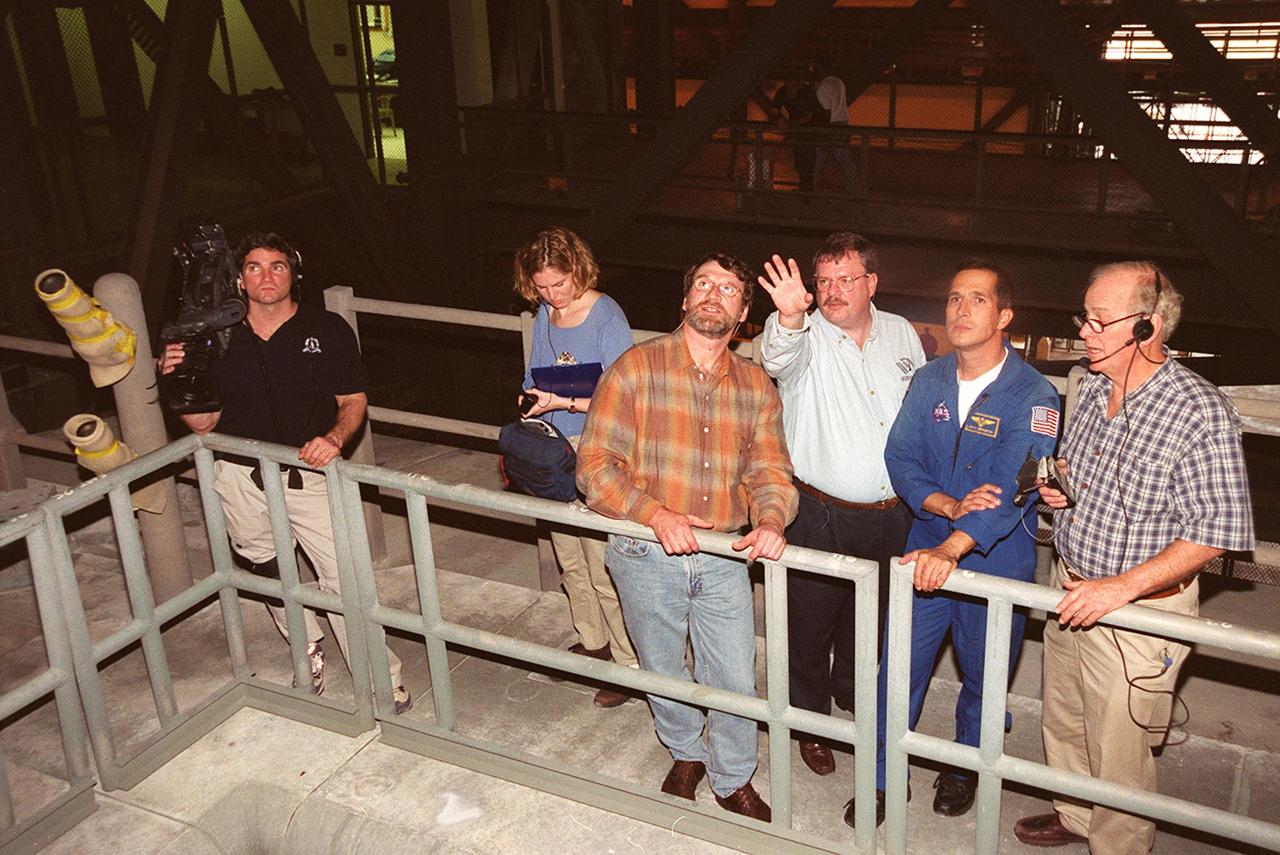 Members of the crew of the television series This Old House get a close look at Space Shuttle Atlantis in the Vehicle Assembly Building. In the center is Norm Abram, master carpenter on the series. Second from the right is astronaut John Herrington, who is accompanying the film crew on their tour of KSC. The cast and crew of This Old House are filming at KSC for an episode of the show