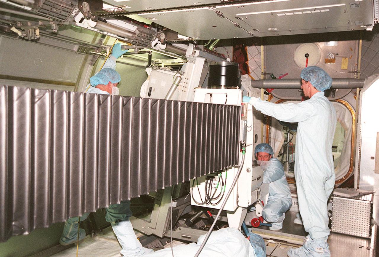 KENNEDY SPACE CENTER, FLA. -- Workers inside the Multi-Purpose Logistics Module Leonardo check installation of a laboratory rack inside the Multi-Purpose Logistics Module Leonardo. The pressurized module is the first of three that will serve as the International Space Station's “moving vans,” carrying laboratory racks filled with equipment, experiments and supplies to and from the Space Station aboard the Space Shuttle. Approximately 21 feet long and 15 feet in diameter, Leonardo will be launched on Shuttle mission STS-102 March 1, 2001. On that flight, Leonardo will be filled with equipment and supplies to outfit the U.S. laboratory module, being carried to the ISS on the Jan. 19, 2001, launch of STS-98
