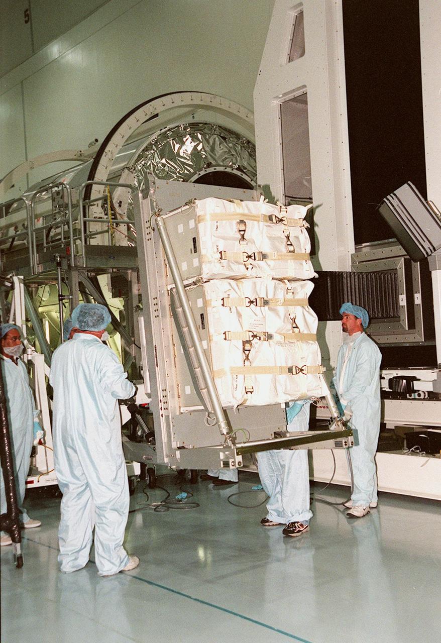 KENNEDY SPACE CENTER, FLA. -- In the Space Station Processing Facility, another laboratory rack is placed on the arm of the Rack Insertion Unit to lift it to the workstand height of the Multi-Purpose Logistics Module Leonardo (not seen). The MPLM will transport laboratory racks filled with equipment, experiments and supplies to and from the International Space Station aboard the Space Shuttle. Leonardo will be launched for the first time March 1, 2001, on Shuttle mission STS-102. On that flight, Leonardo will be filled with equipment and supplies to outfit the U.S. laboratory module, being carried to the ISS on the Jan. 19, 2001, launch of STS-98