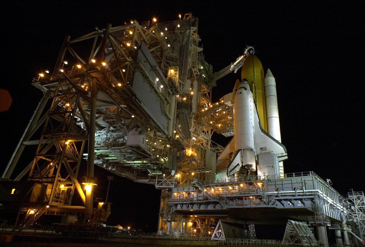 KENNEDY SPACE CENTER, Fla. -- After rollback of the Rotating Service Structure on Launch Pad 39B, Space Shuttle Endeavour is bathed in light. Seen is one of the twin solid rocket boosters that flank the orange external tank. Above the external tank is the Gaseous Oxygen Vent Arm that vents gaseous oxygen vapors away from the Shuttle. The vent hood assembly at the end is often referred to as the "beanie cap." Stretching to the crew hatch on the side is the Orbiter Access Arm with its environmentally controlled White Room at the end. The Shuttle sits on the Mobile Launcher Platform with the two service tail masts on either side of the main engines. The tail masts support the fluid, gas and electrical requirements of the orbiter's liquid oxygen and liquid hydrogen aft T-0 umbilicals. Each tail mast is 31 feet (9.4 meters) high, 15 feet (4.6 meters) long and 9 feet (3.1 meters) wide. Endeavour is scheduled to launch on mission STS-108 Nov. 29 at 7:41 p.m. On this 12th flight to the International Space Station, known as a Utilization Flight, Endeavour will carry a crew of four plus the Expedition 4 crew, who will replace Expedition 3 aboard the ISS. The payload includes the Multi-Purpose Logistics Module Raffaello, filled with supplies, equipment and experiments