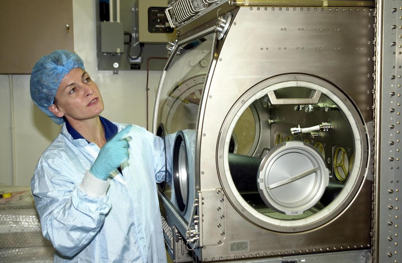 KENNEDY SPACE CENTER, FLA. -- Astronaut Peggy Whitson, a member of the Expedition 5 crew, points to a part of the equipment she is using as part of familiarization for the mission. She and other crew members Commander Valeri Korzun and Sergei Treschev will be traveling to the International Space Station on mission STS-111 and will be replacing the Expedition 4 crew. Part of the payload on STS-111 will be the Mobile Base System, to be installed installed on the Mobile Transporter to complete the Canadian Mobile Servicing System, or MSS. The mechanical arm will then have the capability to "inchworm" from the U.S. Lab fixture to the MSS and travel along the Truss to work sites. STS-111 is scheduled to launch in May 2002