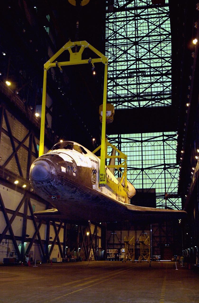 The orbiter Discovery (seen from the front) is lifted to vertical in the transfer aisle of the Vehicle Assembly Building. It will then be lifted up and into high bay 1 for mating with its solid rocket boosters and external tank. Discovery will be launched March 8 on mission STS-102, the eighth construction flight to the International Space Station. The Shuttle will carry the Multi-Purpose Logistics Module Leonardo, the first of three pressurized modules provided by the Italian Space Agency to carry supplies and equipment to the Space Station and back to earth