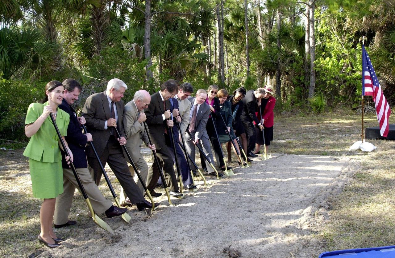 At a groundbreaking ceremony, participants and guests get ready to dig in, signifying the start of construction on a new roadway through KSC. It is the start of a construction project that includes the Space Experiment Research & Processing Laboratory (SERPL). From left are Dr. Pamella J. Dana, from the executive office of Florida’s governor, Jeb Bush; Deputy Associate Administrator Michael Hawes, Space Station, NASA; Sen. George Kirkpatrick; Spaceport Florida Authority Executive Director Ed Gormel; Executive Director Dr. Samuel T. Durrance, Florida Space Research Institute; Florida’s Lt. Gov. Frank Brogan; Congressman Dave Weldon; Center Director Roy Bridges Jr.; SFA SERPL Program Manager Debra Holliday; KSC SERPL Program Manager Jan Heuser; District Manager Cheryl Harrison-Lee, Florida Department of Transportation; State Senator Jim Sebesta; and KSC Director JoAnn H. Morgan, External Relations and Business Development. The project is enabled by a partnership and collaboration between NASA and the State of Florida to create a vital resource for international and commercial space customers. SERPL is considered a magnet facility, and will support the development and processing of life sciences experiments destined for the International Space Station and accommodate NASA, industry and academic researchers performing associated biological research