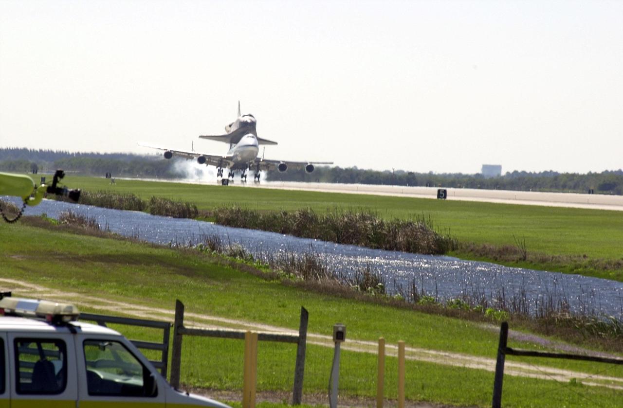 KENNEDY SPACE CENTER, FLA. -- The Shuttle Carrier Aircraft, a modified Boeing 747, kicks up dust as it touches down at KSC’s Shuttle Landing Facility. It is carrying the orbiter Atlantis on top. Strong cross winds caused the SCA to land left wheels first. Atlantis landed in California Feb. 19 concluding mission STS-98. The ferry flight began in California March 1; unfavorable weather conditions kept it on the ground at Altus AFB, Okla., until it could return to Florida. The orbiter will next fly on mission STS-104, the 10th construction flight to the International Space Station, scheduled June 8