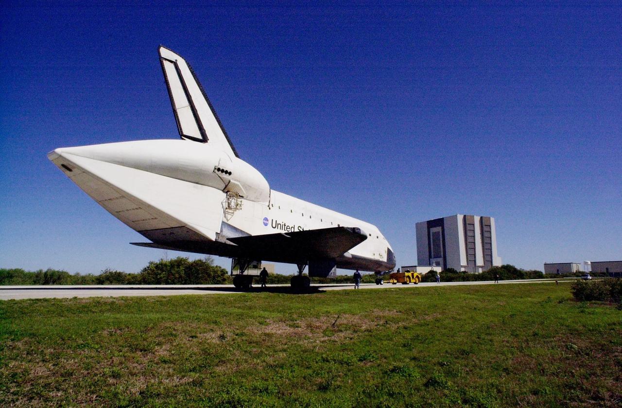 KENNEDY SPACE CENTER, FLA. -- Orbiter Atlantis is towed to the Orbiter Processing Facility bay 3 along the tow-way. In the background is the Vehicle Assembly Building. The unusual silhouette of the aft section on the orbiter is due to the tail cone covering the aft engines. Atlantis landed Feb. 19 at Edwards Air Force Base concluding mission STS-98. The orbiter returned to Florida on the back of a Shuttle Carrier Aircraft, known as a ferry flight, that began March 1. Unfavorable weather conditions kept it on the ground at Altus AFB, Okla., for several days until it could return to Florida. Atlantis will be prepared in the OPF for mission STS-104, the 10th construction flight to the International Space Station, scheduled to launch June 8