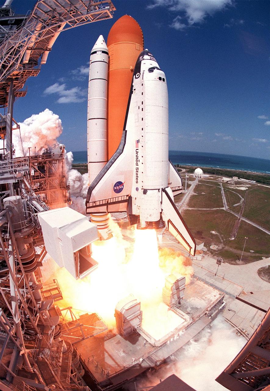 KENNEDY SPACE STATION, FLA. -- Space Shuttle Endeavour hurtles into a clear blue sky from Launch Pad 39A on mission STS-100. On the horizon is the Atlantic Ocean. Liftoff of the ninth flight to the International Space Station occurred at 2:40:42 p.m. EDT. The 11-day mission will deliver and integrate the Spacelab Logistics Pallet/Launch Deployment Assembly, which includes the Space Station Remote Manipulator System and the UHF Antenna. The mission includes two planned spacewalks for installation of the SSRMS on the Station. Also onboard is the Multi-Purpose Logistics Module Raffaello, carrying resupply stowage racks and resupply/return stowage platforms. <i>(Photo by Red Huber, Orlando Sentinel)</i