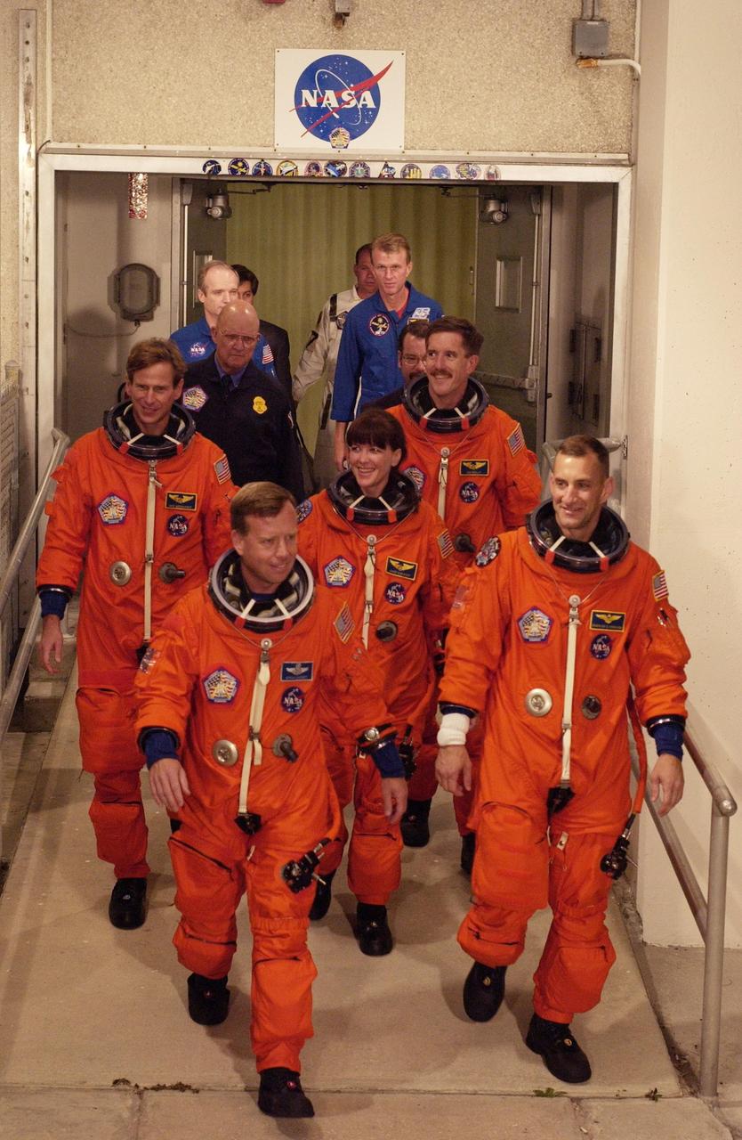 KENNEDY SPACE CENTER, Fla. -- The STS-104 crew exits out of the Operations and Checkout Building on their way to Launch Pad 39B. Leading are Commander Steven W. Lindsey (left) and Pilot Charles O. Hobaugh. In the center is Mission Specialist Janet Lynn Kavandi. Following her are Mission Specialists Michael L. Gernhardt (left) and James F. Reilly. . The launch of Space Shuttle Atlantis on mission STS-104 is targeted for 5:04 a.m., July 12, from Launch Pad 39B. The primary payload on the mission is the joint airlock module, which will be added to the International Space Station. The airlock will be the primary path for Space Station spacewalk entry and departure for U.S. spacesuits, and will also support the Russian Orlan spacesuit for EVA activity. D1X NIKON Photo by S. Andrews