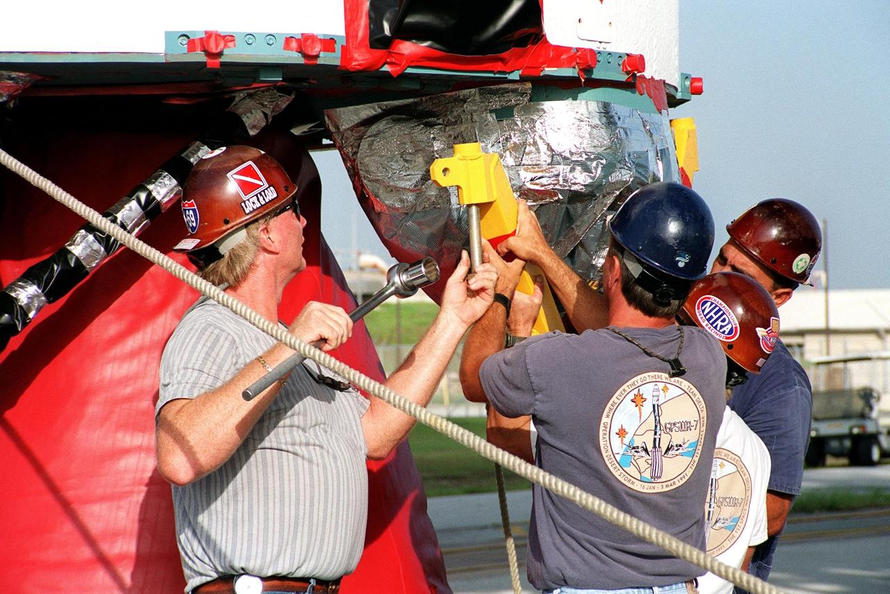 KENNEDY SPACE CENTER, Fla. -- On Launch Complex 17A, Cape Canaveral Air Force Station, technicians work on the bottom of the first stage of a Delta II rocket before its lift up the gantry. The rocket will propel the Genesis spacecraft on a journey to capture samples of the ions and elements in the solar wind and return them to Earth for scientists to use to determine the exact composition of the Sun and the solar system’s origin. NASA's Genesis project in managed by the Jet Propulsion Laboratory in Pasadena, Calif. Lockheed Martin Astronautics built the Genesis spacecraft for NASA in Denver, Colo. The launch is scheduled for July 30 at 12:36 p.m. EDT