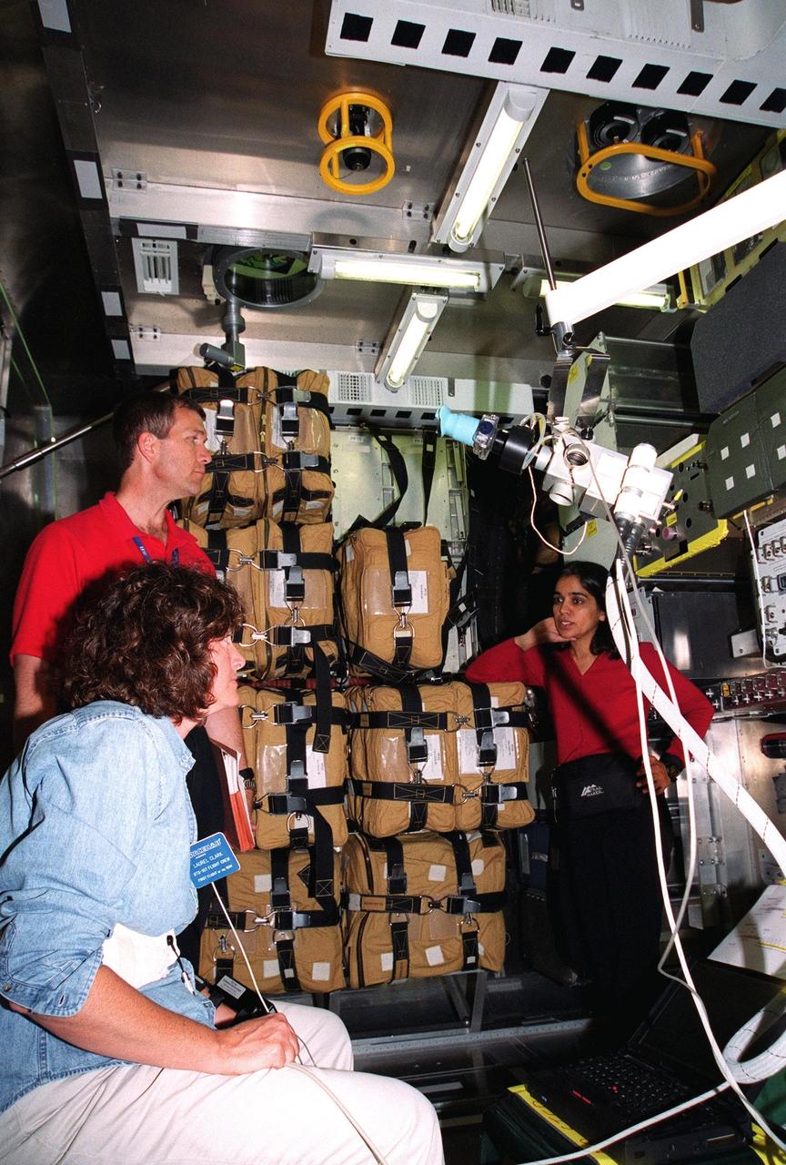 KENNEDY SPACE CENTER, Fla. -- At SPACEHAB, Cape Canaveral, Fla., members of the STS-107 crew discuss the experiments in the Spacehab module. Seated, in the foreground, is Mission Specialist Laurel Blair Salton Clark; standing behind her are Commander Rick Douglas Husband and Mission Specialist Kalpana Chawla. They and other crew members Pilot William C. McCool; Payload Commander Michael P. Anderson; and Mission Specialists David M. Brown and Ilan Ramon, of Israel, are at SPACEHAB for Crew Equipment Interface Test (CEIT) activities. The CEIT enables the crew to perform certain flight operations, operate experiments in a flight-like environment, evaluate stowage locations and obtain additional exposure to specific experiment operations. As a research mission, STS-107 will carry the Spacehab Double Module in its first research flight into space and a broad collection of experiments ranging from material science to life science. STS-107 is scheduled for launch May 23, 2002