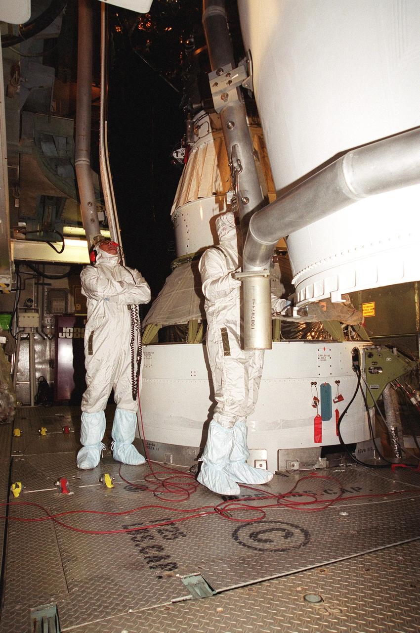 KENNEDY SPACE CENTER, Fla. -- Workers at Launch Complex 17-B, Cape Canaveral Air Force Station, oversee the fairing installation on the Microwave Anisotropy Probe (MAP) spacecraft. MAP is scheduled for launch on June 30 aboard a Boeing Delta II rocket. The launch will place MAP into a lunar-assisted trajectory to the Sun-Earth for a 27-month mission. The probe will measure small fluctuations in the temperature of the cosmic microwave background radiation to an accuracy of one millionth of a degree. These measurements should reveal the size, matter content, age, geometry and fate of the universe. They will also reveal the primordial structure that grew to form galaxies and will test ideas about the origins of these primordial structures. The MAP instrument will be continuously shaded from the Sun, Earth, and Moon by the spacecraft