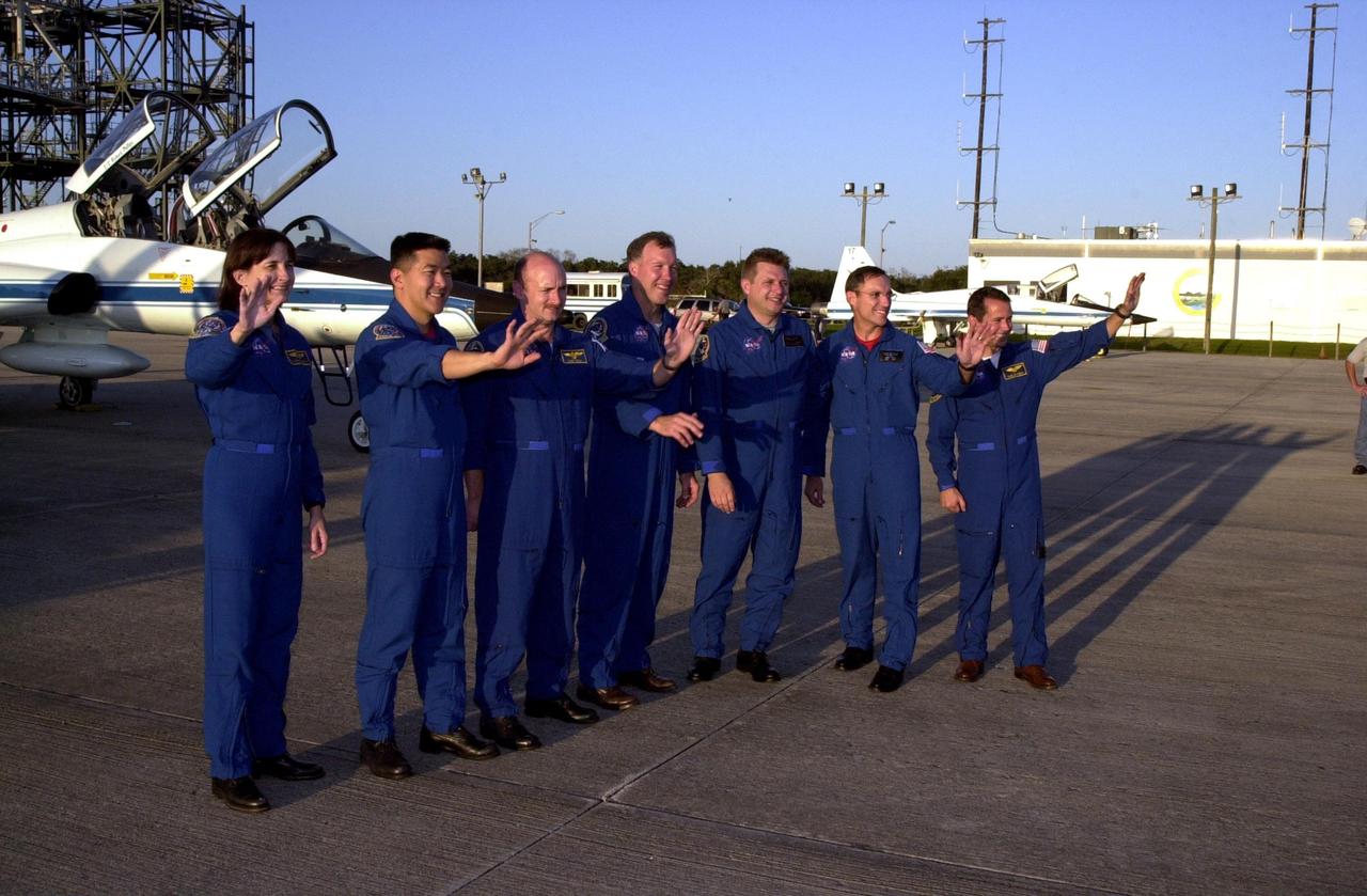 KENNEDY SPACE CENTER, Fla. -- After arriving at the KSC Shuttle Landing Facility, the STS-108 and Expedition 4 crews wave to the media who waited for comments from the crew. Standing, left to right, are Mission Specialists Linda A. Godwin and Daniel M. Tani, Pilot Mark E. Kelly, and Commander Dominic L. Gorie; Expedition 4 Commander Yuri Onufrienko and crew members Carl E. Walz and Daniel W. Bursch. Top priorities for the STS-108 (UF-1) mission of Endeavour are rotation of the International Space Station Expedition Three and Expedition Four crews, bringing water, equipment and supplies to the station in the Multi-Purpose Logistics Module Raffaello, and completion of spacewalk and robotics tasks. Tani and Godwin will take part in the spacewalk to install thermal blankets over two pieces of equipment at the bases of the Space Station's solar wings. Liftoff is scheduled for 7:41 p.m. EST