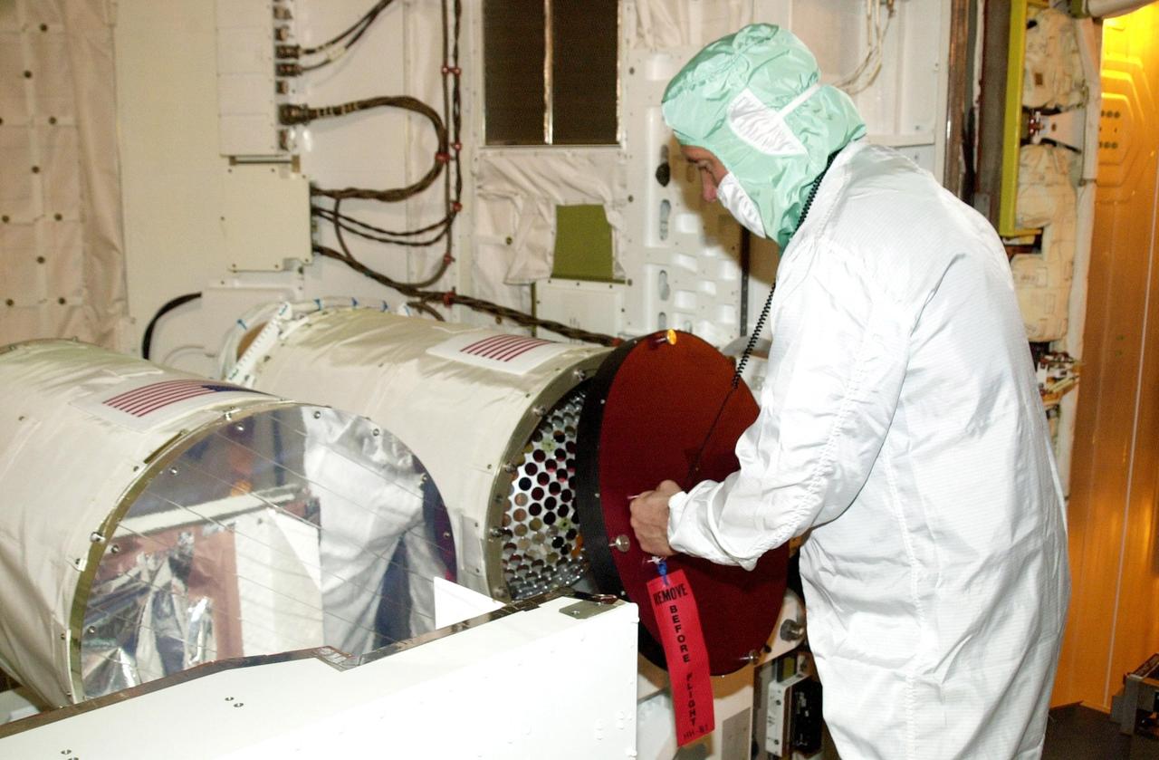 KENNEDY SPACE CENTER, Fla. --  A technician removes the cover of the canister holding the Starshine-2 experiment.  The canister is in the payload bay of Space Shuttle Endeavour.  The deployable experiment is being carried on mission STS-108.  Starshine-2's 800 aluminum mirrors were polished by more than 25,000 students from 26 countries. Top priorities for the STS-108 (UF-1) mission of Endeavour are rotation of the International Space Station Expedition Three and Expedition Four crews, bringing water, equipment and supplies to the station in the Multi-Purpose Logistics Module Raffaello, and completion of robotics tasks and a spacewalk to install thermal blankets over two pieces of equipment at the bases of the Space Station's solar wings. Liftoff of Endeavour on mission STS-108 is scheduled for 7:41 p.m. EST