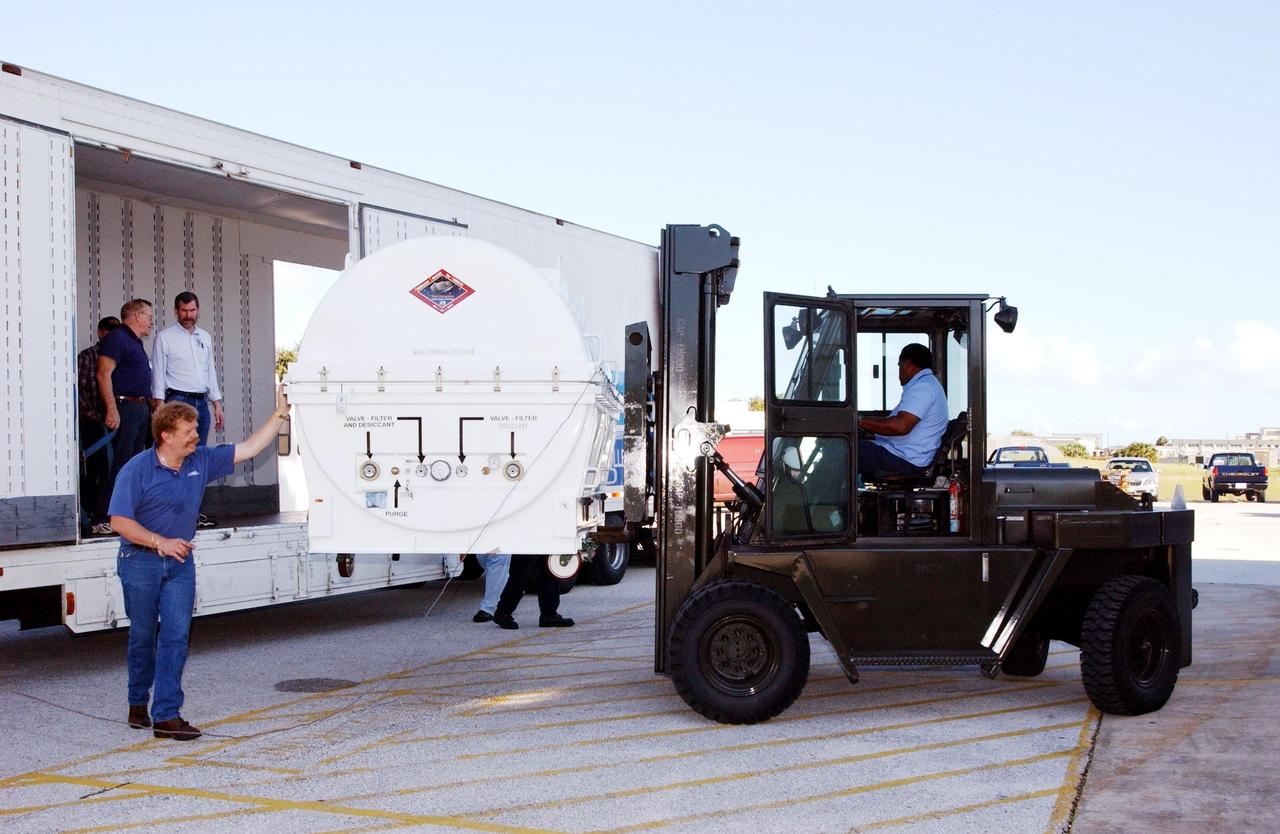 KENNEDY SPACE CENTER, Fla. -  A piece of equipment for Hubble Space Telescope Servicing mission arrives at Hangar AE, Cape Canaveral.  Inside the canister is the Advanced Camera for Surveys (ACS). The ACS will increase the discovery efficiency of the HST by a factor of ten. It consists of three electronic cameras and a complement of filters and dispersers that detect light from the ultraviolet to the near infrared (1200 - 10,000 angstroms).  The ACS was built through a collaborative effort between Johns Hopkins University, Goddard Space Flight Center, Ball Aerospace Corporation and Space Telescope Science Institute. The goal of the mission, STS-109,  is to service the HST, replacing Solar Array 2 with Solar Array 3, replacing the Power Control Unit, removing the Faint Object Camera and installing the ACS, installing the Near Infrared Camera and Multi-Object Spectrometer (NICMOS) Cooling System, and installing New Outer Blanket Layer insulation on bays 5 through 8.  Mission STS-109 is scheduled for launch Feb. 14, 2002