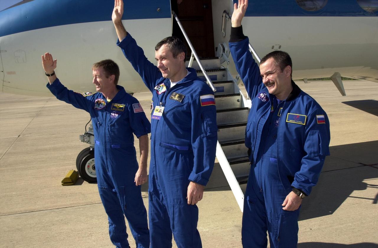 KENNEDY SPACE CENTER, FLA. -- The Expedition Three crew wave farewell before boarding the plane for Houston.   From left to right are Commander Frank Culbertson and cosmonauts Vladimir Dezhurov and Mikhail Tyurin.  The three returned to Earth, and KSC, as passengers aboard the orbiter Endeavour, which landed at 12:55 p.m. EST (17:55 GMT) Dec. 17, 2001, after completing mission STS-108.  Expedition 3 had spent 129 days on the International Space Station.  The landing is the 57th at KSC in the history of the program   STS-108 was the 12th mission to the Space Station.  This mission was the 107th flight in the Shuttle program and the 17th flight for the orbiter