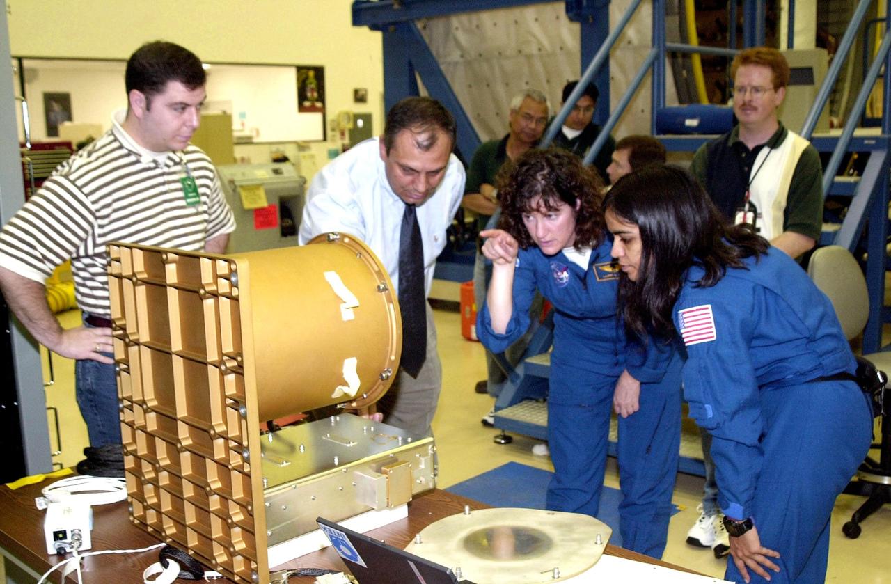 KENNEDY SPACE CENTER, FLA. - At SPACEHAB, Cape Canaveral, Fla., members of the STS-107 crew familiarize themselves with experiments and equipment for the mission. Pointing at a piece of equipment (center) is Mission Specialist Laurel Clark . At right is Mission Specialist Kalpana Chawla. STS-107 is a research mission. The primary payload is the first flight of the SHI Research Double Module (SHI/RDM). The experiments range from material sciences to life sciences (many rats). Also part of the payload is the Fast Reaction Experiments Enabling Science, Technology, Applications and Research (FREESTAR) that incorporates eight high priority secondary attached shuttle experiments: Mediterranean Israeli Dust Experiment (MEIDEX), Shuttle Ozone Limb Sounding Experiment (SOLSE-2), Student Tracked Atmospheric Research Satellite for Heuristic International Networking Experiment (STARSHINE), Critical Viscosity of Xenon-2 (CVX-2), Solar Constant Experiment-3 (SOLOCON-3), Prototype Synchrotron Radiation Detector (PSRD), Low Power Transceiver (LPT), and Collisions Into Dust Experiment -2 (COLLIDE-2). STS-107 is scheduled to launch in July 2002