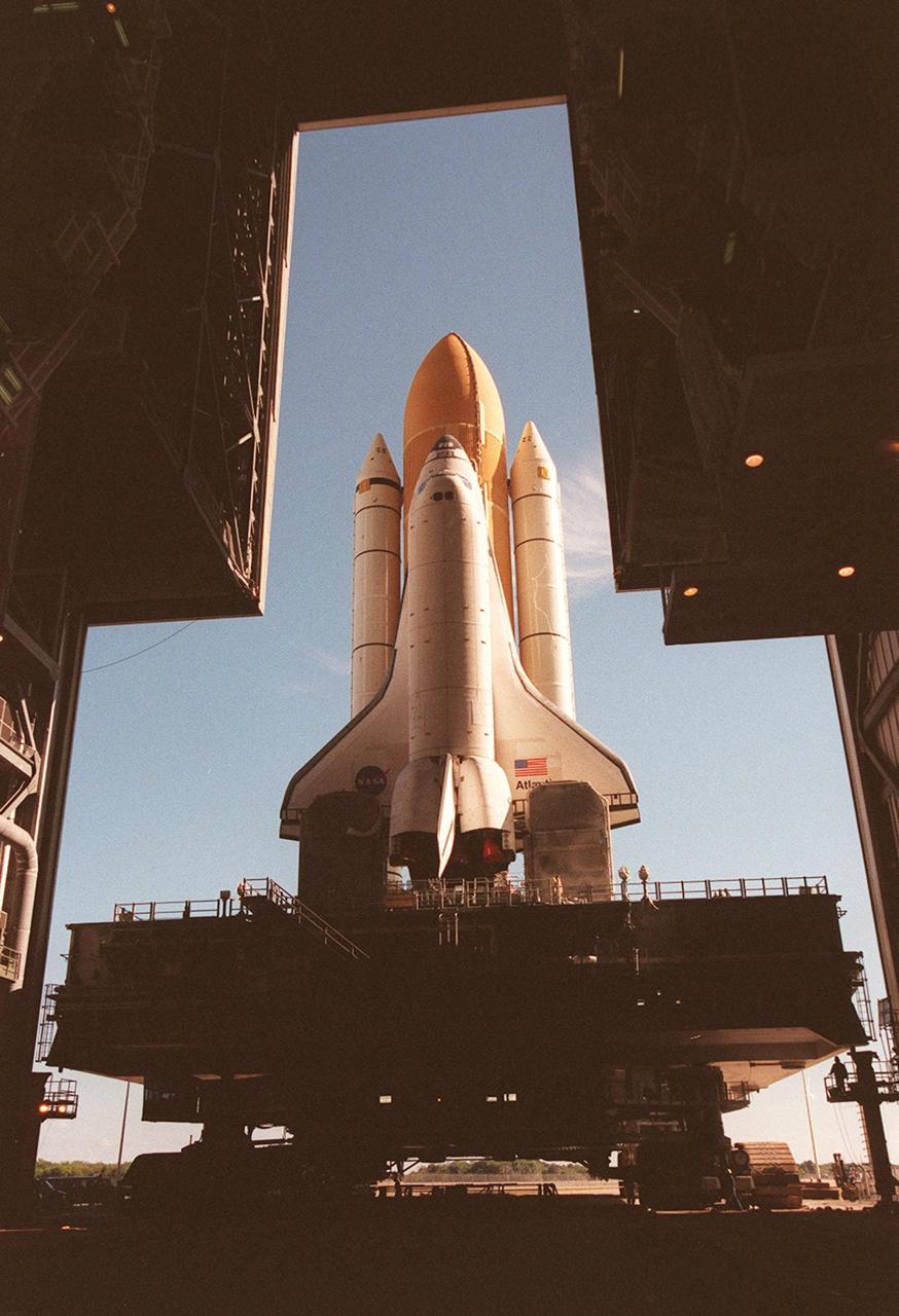 KENNEDY SPACE CENTER, Fla. -- Space Shuttle Atlantis inches its way out the doors of the Vehicle Assembly Building as it begins rolling out to Launch Pad 39A for the second time. An attempt to roll out on Jan. 2 incurred a failed computer processor on the crawler transporter and the Shuttle was returned to the Vehicle Assembly Building using a secondary computer processor on the vehicle. Atlantis will fly on mission STS-98, the seventh construction flight to the International Space Station, carrying the U.S. Laboratory, named Destiny. The lab will have five system racks already installed inside the module. After delivery of electronics in the lab, electrically powered attitude control for Control Moment Gyroscopes will be activated. Atlantis is scheduled for launch no earlier than Jan. 19, 2001, with a crew of five