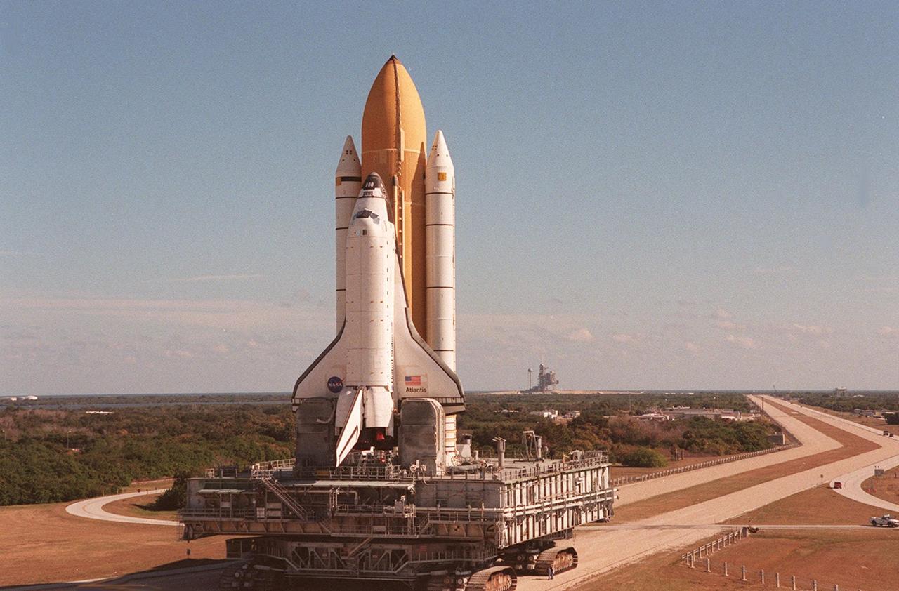 KENNEDY SPACE CENTER, Fla. -- Space Shuttle Atlantis inches its way to Launch Pad 39A for the second time. In the background is the launch pad; the crawlerway leading to it (on the right) extends toward the horizon. An attempt to roll out on Jan. 2 incurred a failed computer processor on the crawler transporter and the Shuttle was returned to the Vehicle Assembly Building using a secondary computer processor on the vehicle. Atlantis will fly on mission STS-98, the seventh construction flight to the International Space Station, carrying the U.S. Laboratory, named Destiny. The lab will have five system racks already installed inside the module. After delivery of electronics in the lab, electrically powered attitude control for Control Moment Gyroscopes will be activated. Atlantis is scheduled for launch no earlier than Jan. 19, 2001, with a crew of five