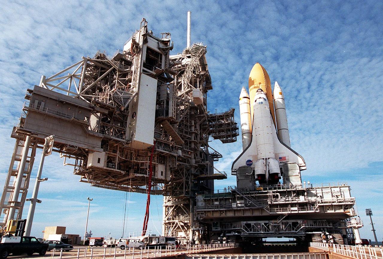 KENNEDY SPACE CENTER, Fla. -- Space Shuttle Atlantis reaches its destination, Launch Pad 39A, for liftoff no earlier than Jan. 19 on mission STS-98. To its immediate left is the Fixed Service Structure, with its 80-foot-tall white lighting mast on top. Further to the left is the Rotating Service Structure, where the white payload canister is being lifted to the Payload Changeout Room. The payload for the mission is the U.S. Lab Destiny, a key element in the construction of the International Space Station. The lab has five system racks for experiments already installed inside the module. After delivery of electronics in the lab, electrically powered attitude control for Control Moment Gyroscopes will be activated