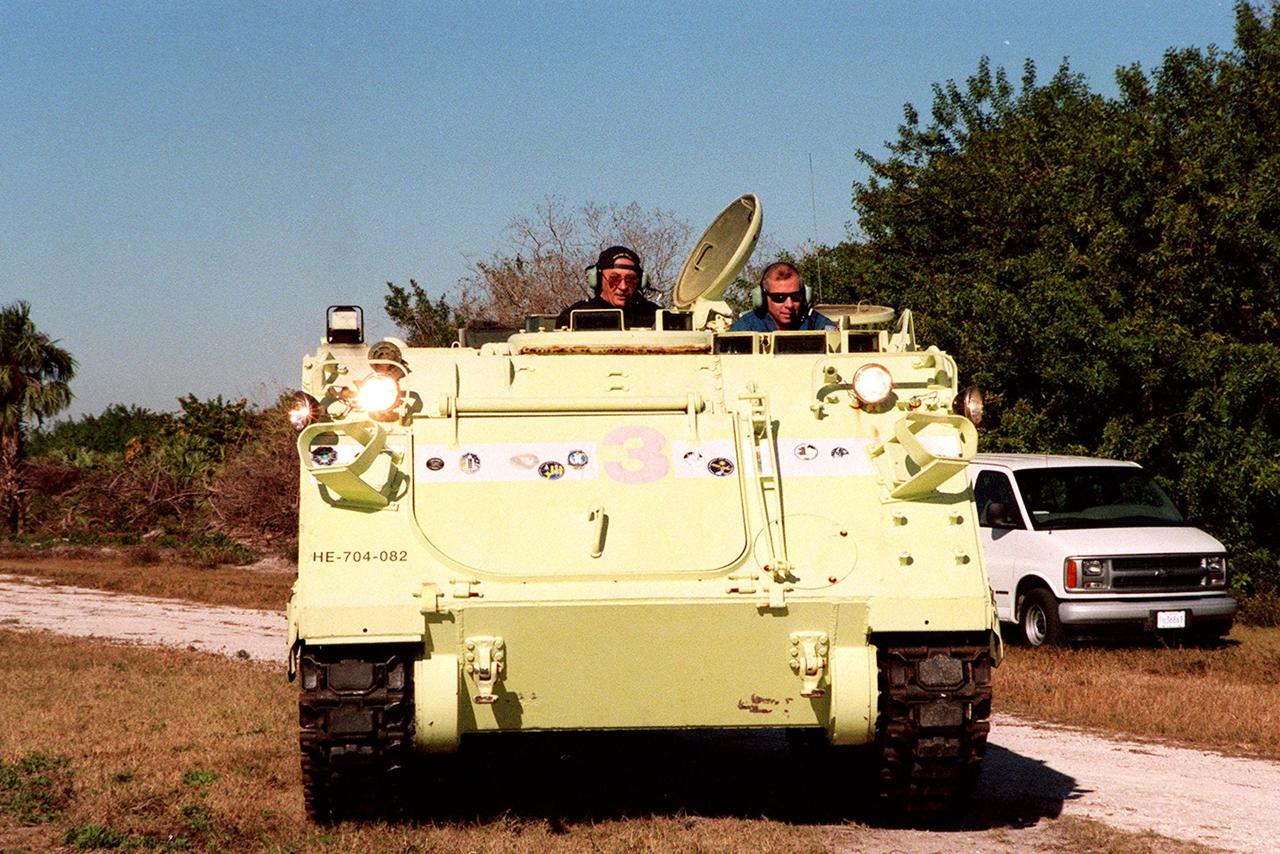 Capt. George Hoggard (left), a training officer with SGS Fire Services, sits alongside STS-98 Commander Ken Cockrell, who practices driving an M-113 armored carrier. In the event of an emergency at the pad prior to launch, the carrier could be used to transport the crew to a nearby bunker or farther. The vehicle is part of emergency egress training at Launch Pad 39A. The STS-98 crew is at KSC to take part in Terminal Countdown Demonstration Test activities, which also includes a simulated launch countdown. STS-98 is the seventh construction flight to the International Space Station, carrying as payload the U.S. Lab Destiny, a key element in the construction of the ISS