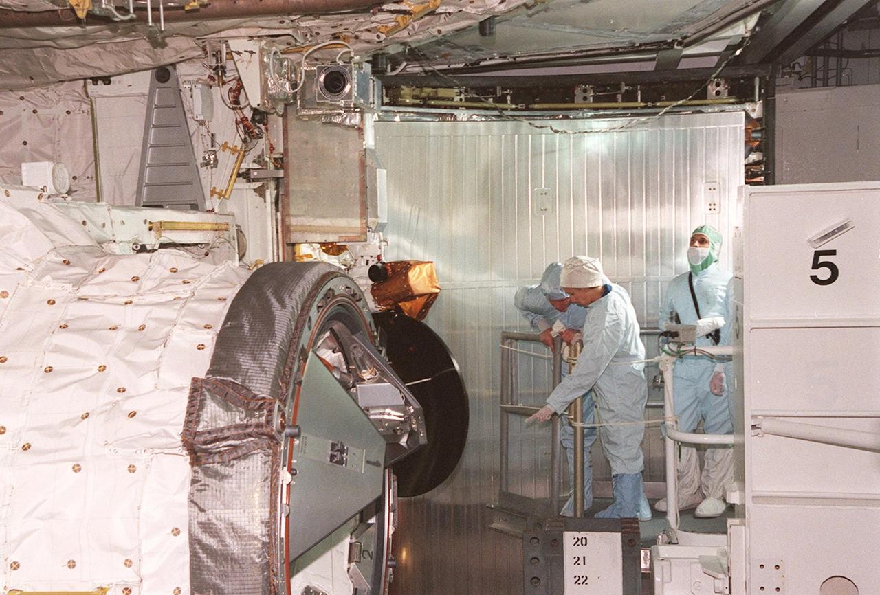 KENNEDY SPACE CENTER, FLA. -- STS-98 Mission Specialist Marsha Ivins (center, pointing) checks out the U.S. Lab Destiny in the payload bay of the orbiter Atlantis. The crew is at KSC for Terminal Countdown Demonstration Test activities, which also include a simulated launch countdown. Destiny, a key element in the construction of the International Space Station, is a pressurized module designed to accommodate pressurized payloads. It has a capacity of 24 rack locations. Payload racks will occupy 13 locations especially designed to support experiments. The module already has five system racks installed inside. Launch of STS-98 on its 11-day mission is scheduled for Jan. 19 at 2:11 a.m. EST
