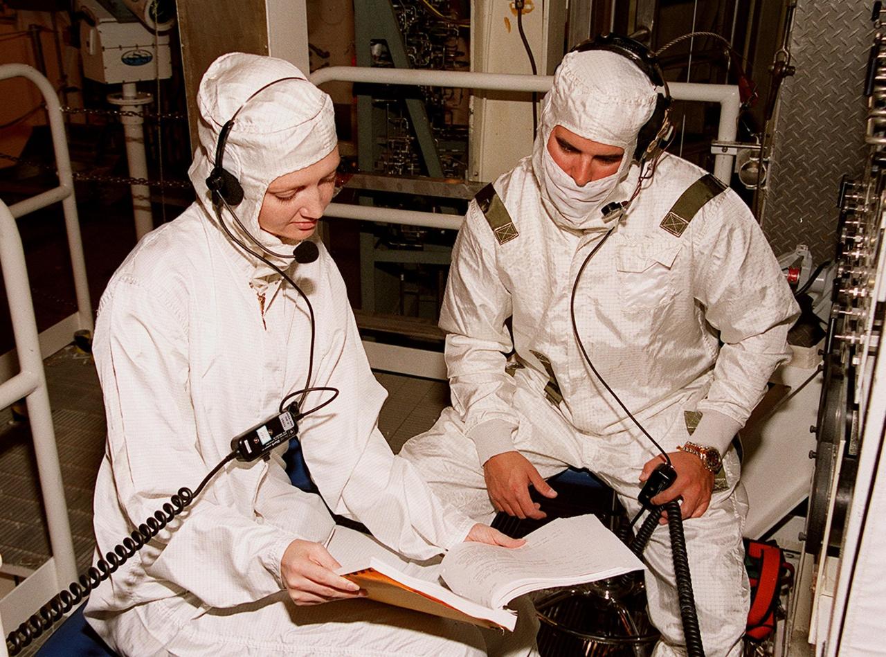 KENNEDY SPACE CENTER, FLA. -- In the Payload Changeout Room at Launch Pad 39A, technicians read a manual on the Payload Ground-Handling Mechanism hook instrumentation unit. The PGHM will be used in moving the U.S. Lab Destiny out of the payload canister and into the PCR. Destiny will then be transferred to the payload bay of Atlantis for mission STS-98. A key element in the construction of the International Space Station, Destiny is designed for space science experiments. STS-98 is the seventh construction flight to the ISS. Launch of STS-98 is scheduled for Jan. 19 at 2:11 a.m. EST