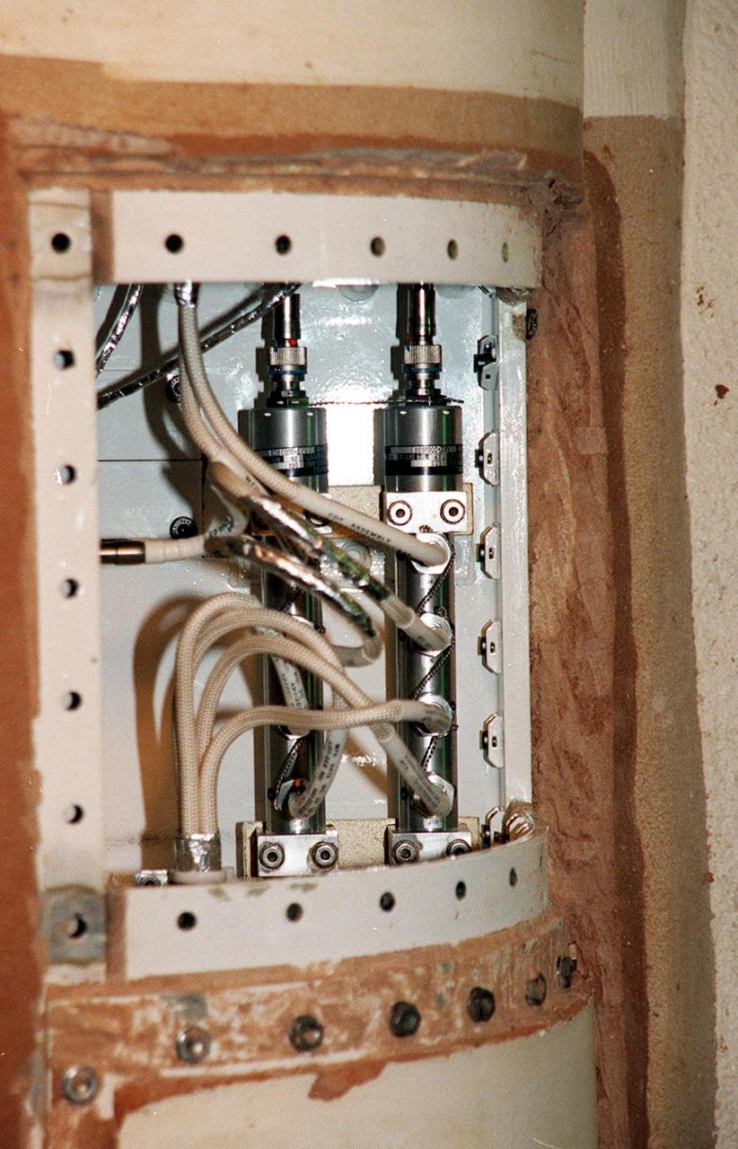 KENNEDY SPACE CENTER, FLA. -- Solid rocket booster cables are exposed after removal of the SRB system tunnel cover. The SRB is part of Space Shuttle Atlantis, rolled back from Launch Pad 39A in order to conduct tests on the cables. A prior extensive evaluation of NASA’s SRB cable inventory on the shelf revealed conductor damage in four (of about 200) cables. Shuttle managers decided to prove the integrity of the system tunnel cables already on Atlantis before launching. Workers are conducting inspections, making continuity checks and conducting X-ray analysis on the cables. The launch has been rescheduled no earlier than Feb. 6. <br