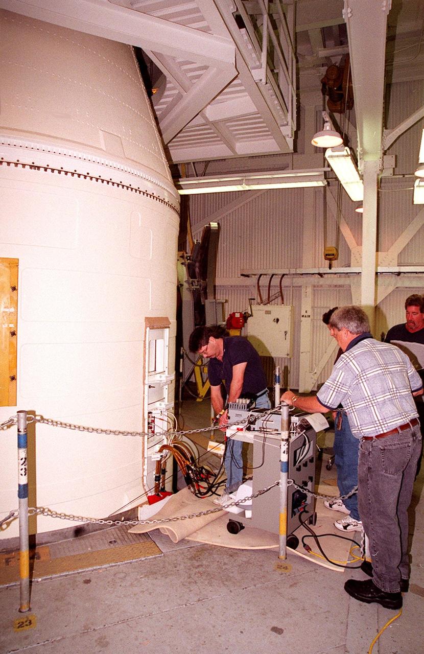 KENNEDY SPACE CENTER, FLA. -- Working near the top of a solid rocket booster, NASA and United Space Alliance SRB technicians hook up SRB cables to a Cirris Signature Touch 1 cable tester. From left are Steve Swichkow, with NASA, and Jim Silviano (back to camera) and Jeff Suter, with USA. The SRB is part of Space Shuttle Atlantis, rolled back from Launch Pad 39A in order to conduct tests on the cables. A prior extensive evaluation of NASA’s SRB cable inventory on the shelf revealed conductor damage in four (of about 200) cables. Shuttle managers decided to prove the integrity of the system tunnel cables already on Atlantis before launching. Workers are conducting inspections, making continuity checks and conducting X-ray analysis on the cables. The launch has been rescheduled no earlier than Feb. 6. <br