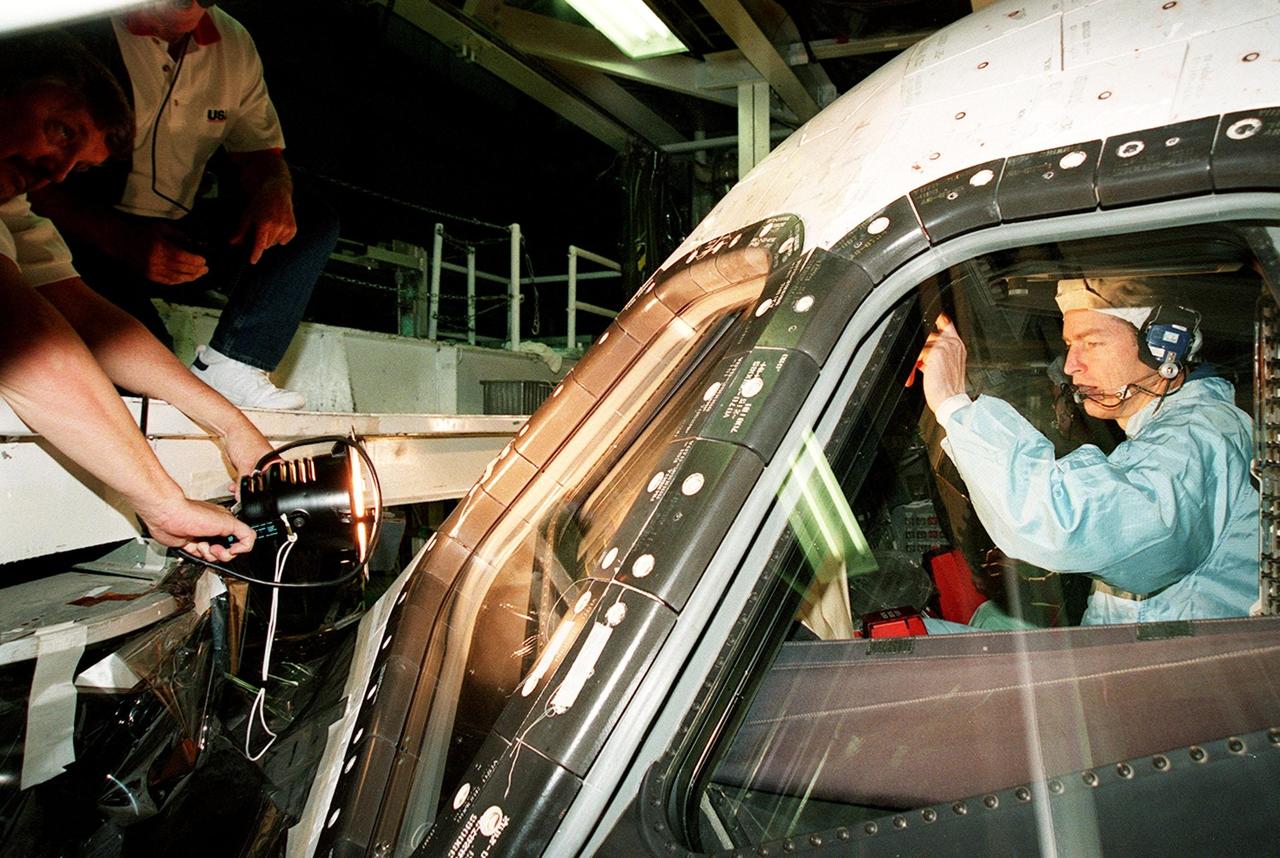 In the Orbiter Processing Facility bay 1, STS-102 Commander James D. Wetherbee checks out the window of Discovery from the inside while workers (left) check the outside.; The mission crew is at KSC for Crew Equipment Interface Test activities. STS-102 is the 8th construction flight to the International Space Station and will carry the Multi-Purpose Logistics Module Leonardo. STS-102 is scheduled for launch March 1, 2001. On that flight, Leonardo will be filled with equipment and supplies to outfit the U.S. laboratory module Destiny. The mission will also be carrying the Expedition Two crew to the Space Station, replacing the Expedition One crew who will return on Shuttle Discovery