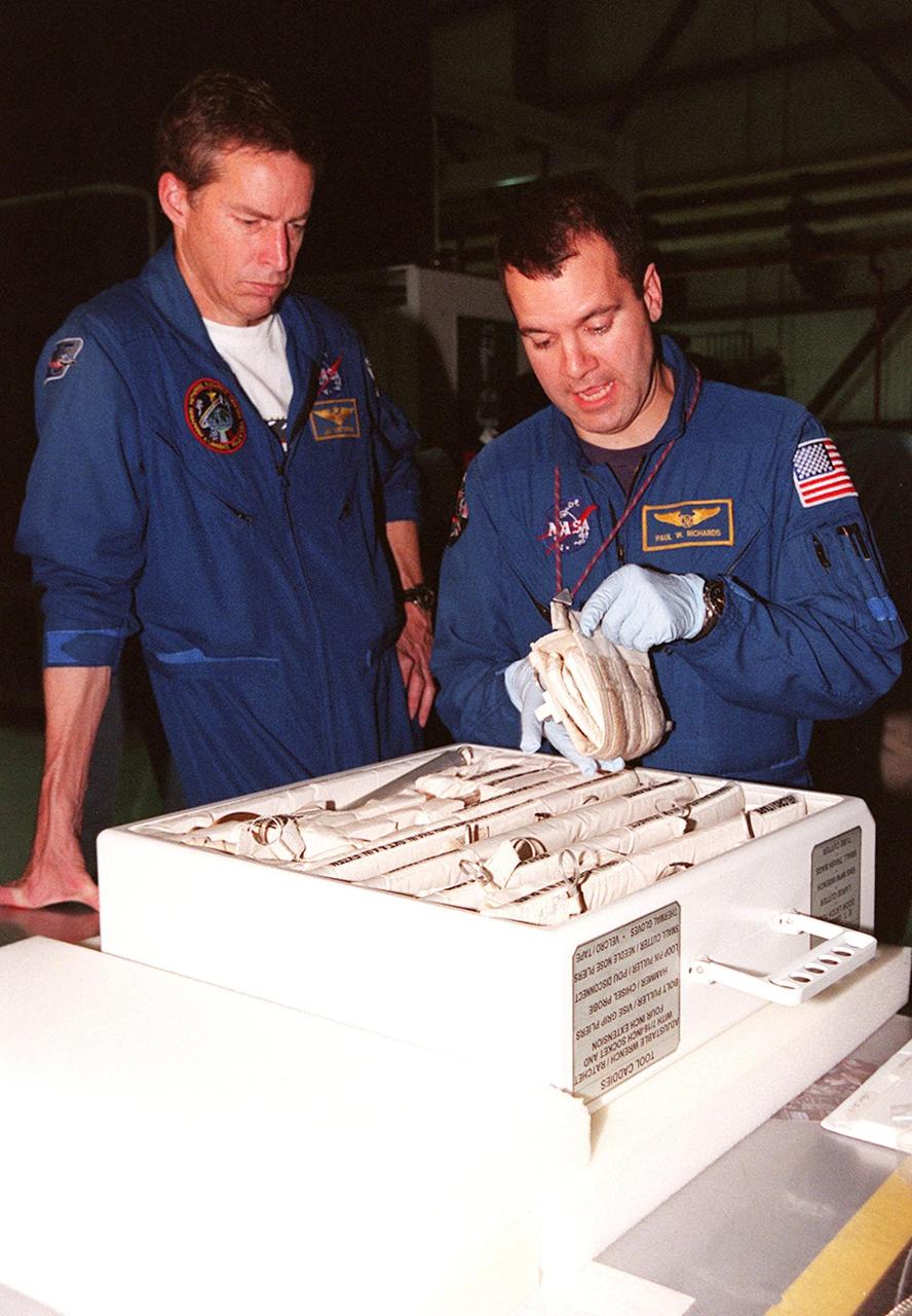 STS-102 Commander James D. Wetherbee watches as Mission Specialist Paul W. Richards handles some of the equipment inside the tool caddy that is carried on launches. The mission crew is at KSC for Crew Equipment Interface Test activities. STS-102 is the 8th construction flight to the International Space Station and will carry the Multi-Purpose Logistics Module Leonardo. STS-102 is scheduled for launch March 1, 2001. On that flight, Leonardo will be filled with equipment and supplies to outfit the U.S. laboratory module Destiny. The mission will also be carrying the Expedition Two crew to the Space Station, replacing the Expedition One crew who will return on Shuttle Discovery