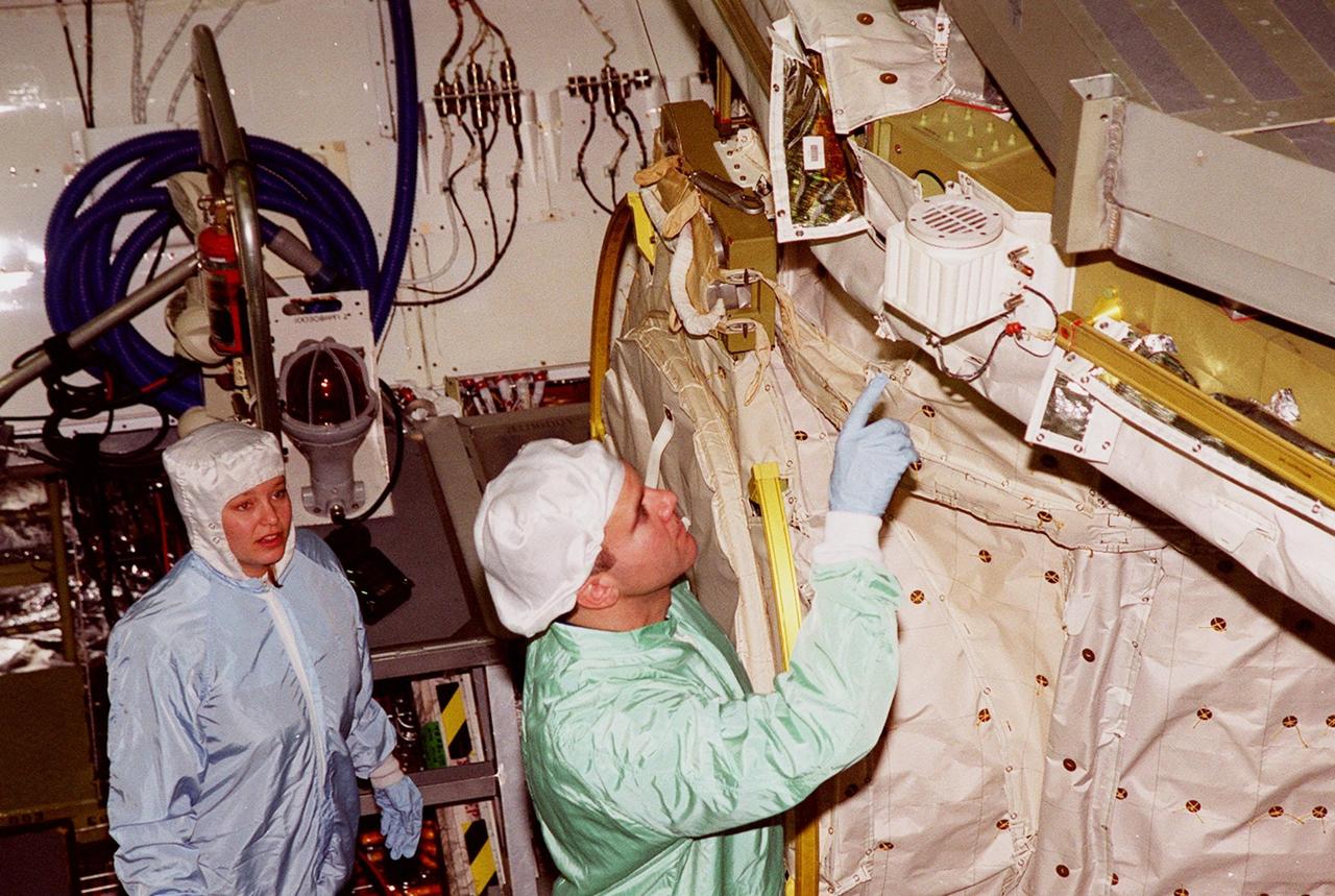 In the Orbiter Processing Facility bay 1, STS-102 Pilot James W. Kelly (right) points to a piece of equipment in Discovery’s payload bay. The crew is at KSC for Crew Equipment Interface Test activities. STS-102 is the 8th construction flight to the International Space Station and will carry the Multi-Purpose Logistics Module Leonardo. STS-102 is scheduled for launch March 1, 2001. On that flight, Leonardo will be filled with equipment and supplies to outfit the U.S. laboratory module Destiny. The mission will also be carrying the Expedition Two crew to the Space Station, replacing the Expedition One crew who will return on Shuttle Discovery