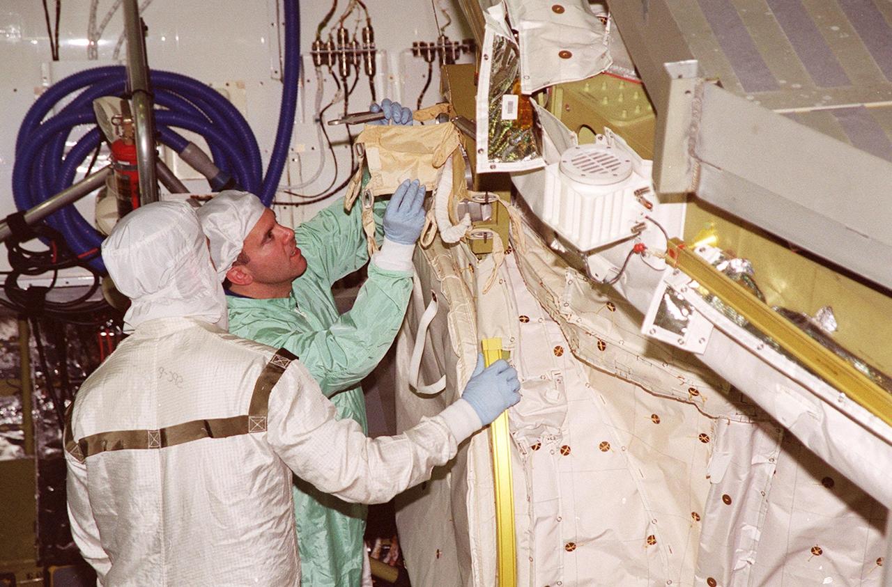 In the Orbiter Processing Facility bay 1, STS-102 Pilot James W. Kelly (right) checks out equipment in Discovery’s payload bay. The crew is at KSC for Crew Equipment Interface Test activities. STS-102 is the 8th construction flight to the International Space Station and will carry the Multi-Purpose Logistics Module Leonardo. STS-102 is scheduled for launch March 1, 2001. On that flight, Leonardo will be filled with equipment and supplies to outfit the U.S. laboratory module Destiny. The mission will also be carrying the Expedition Two crew to the Space Station, replacing the Expedition One crew who will return on Shuttle Discovery