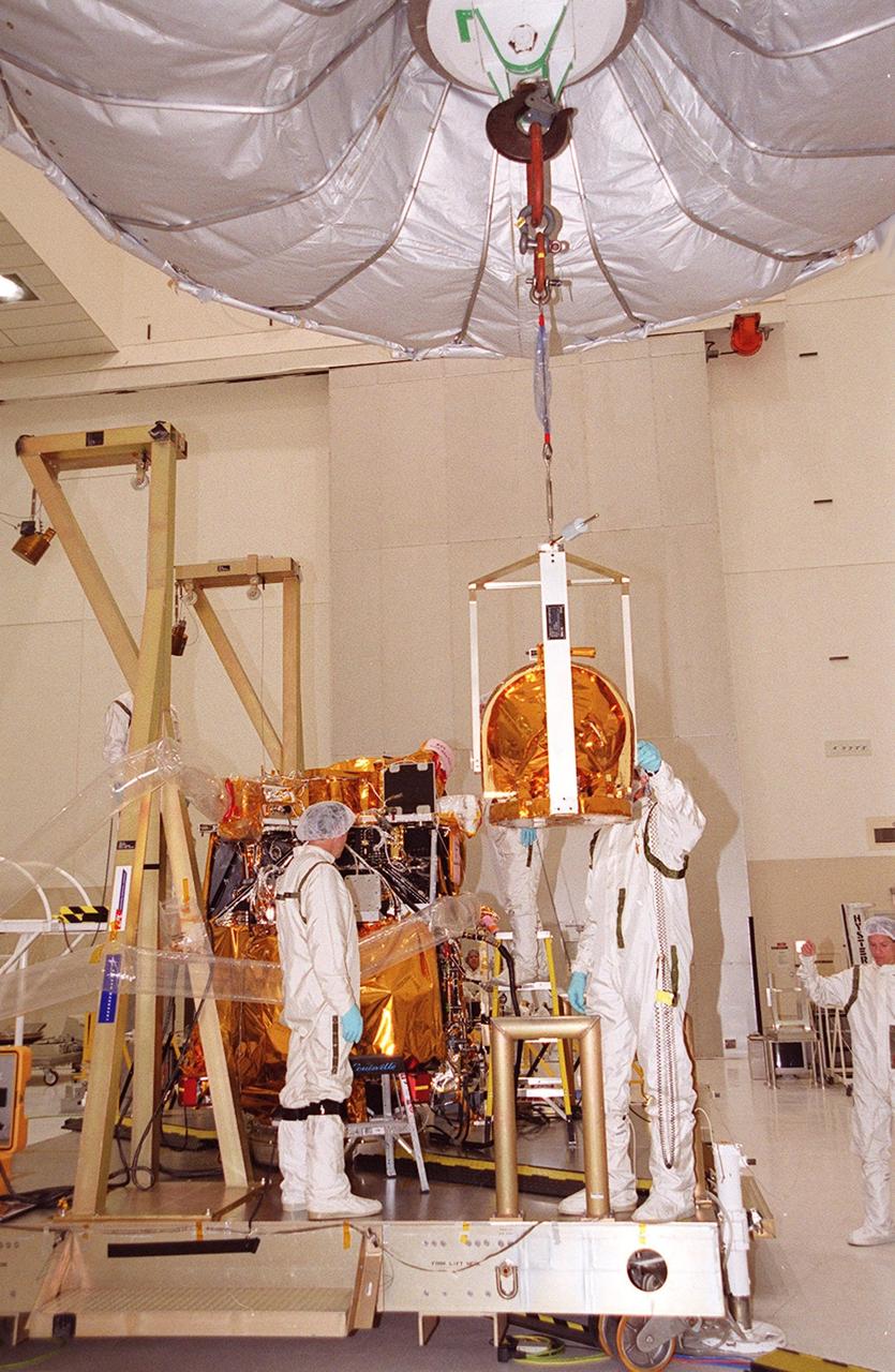 An overhead crane moves The Gamma Ray Spectrometer (GRS) into place to be installed on the Mars Odyssey Orbiter in the Spacecraft Assembly and Encapsulation Facility 2 (SAEF 2).; The orbiter will carry three science instruments: the Thermal Emission Imaging System (THEMIS), the Gamma Ray Spectrometer (GRS), and the Mars Radiation Environment Experiment (MARIE). THEMIS will map the mineralogy and morphology of the Martian surface using a high-resolution camera and a thermal infrared imaging spectrometer. The GRS will achieve global mapping of the elemental composition of the surface and determine the abundance of hydrogen in the shallow subsurface. [The GRS is a rebuild of the instrument lost with the Mars Observer mission.] The MARIE will characterize aspects of the near-space radiation environment with regards to the radiation-related risk to human explorers. The Mars Odyssey Orbiter is scheduled for launch on April 7, 2001, aboard a Delta 7925 rocket from Launch Pad 17-A, Cape Canaveral Air Force Station