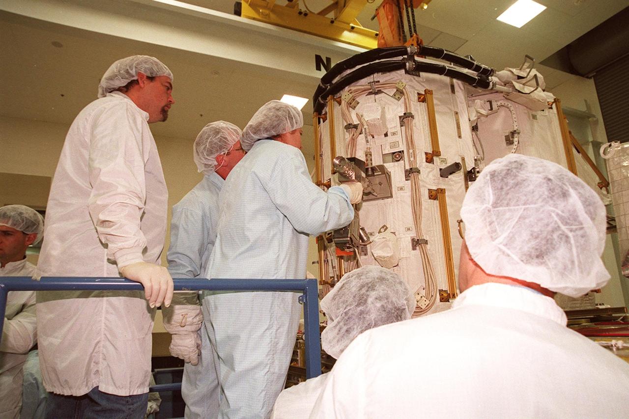 KENNEDY SPACE CENTER, FLA. -- At SPACEHAB, members of the STS-102 crew get acquainted with tools and equipment they will be using on their mission to the International Space Station. Susan Helms (center), who is part of the Expedition Two crew going to the International Space Station, practices with a tool on the Early Ammonia Servicer while Mission Specialist Andrew S.W. Thomas (next to her) looks on. The second spacewalk of the mission will require the crew to transfer the Early Ammonia Servicer to the P6 truss. STS-102 is the 8th construction flight to the International Space Station and will carry the Multi-Purpose Logistics Module Leonardo. On that flight, Leonardo will be filled with equipment and supplies to outfit the U.S. laboratory module Destiny. The mission will also be carrying the Expedition Two crew to the Space Station, replacing the Expedition One crew who will return on Shuttle Discovery. STS-102 is scheduled for launch March 8, 2001