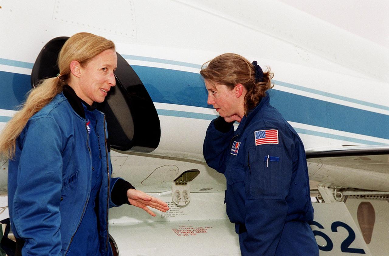 STS-98 Mission Specialist Marsha Ivins (left) speaks to astronaut Pam Melroy, who piloted the T-38 jet that brought Ivins to KSC. Ivins and other crew members Commander Ken Cockrell, Pilot Mark Polansky and Mission Specialists Robert Curbeam and Thomas Jones have returned to KSC to prepare for their launch to the International Space Station. The seventh construction flight to the Space Station, STS-98 will carry the U.S. Laboratory Destiny, a key module for space experiments. The 11-day mission includes three spacewalks to complete outside assembly and connection of electrical and plumbing lines between the laboratory, Station and a relocated Shuttle docking port. STS-98 is Ivins’ fifth space flight. Launch is targeted for Feb. 7 at 6:11 p.m. EST