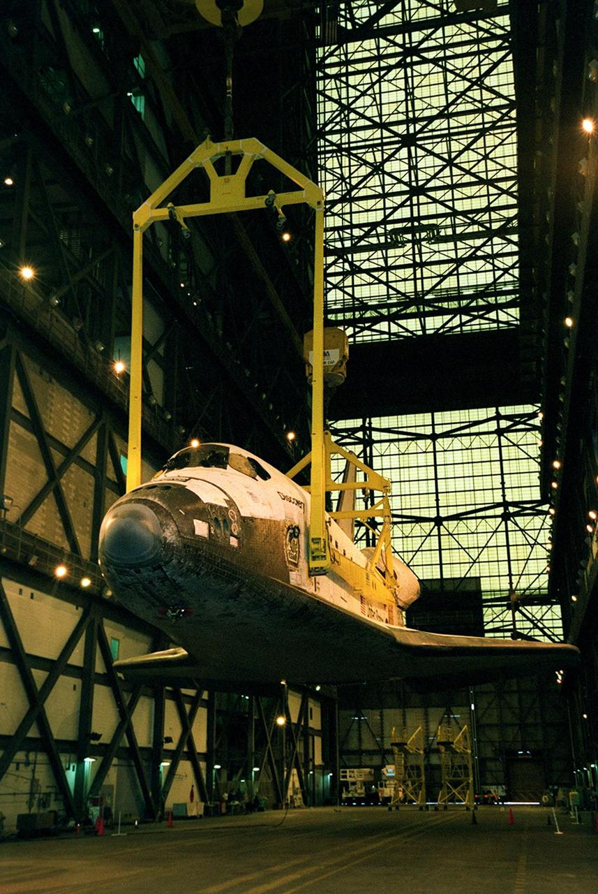 The orbiter Discovery is lifted by cranes in the transfer aisle of the Vehicle Assembly Building. It will next be lifted into a vertical position and into high bay 1 for mating with its solid rocket boosters and external tank. Discovery will be launched March 8 on mission STS-102, the eighth construction flight to the International Space Station. The Shuttle will carry the Multi-Purpose Logistics Module Leonardo, the first of three pressurized modules provided by the Italian Space Agency to carry supplies and equipment to the Space Station and back to Earth