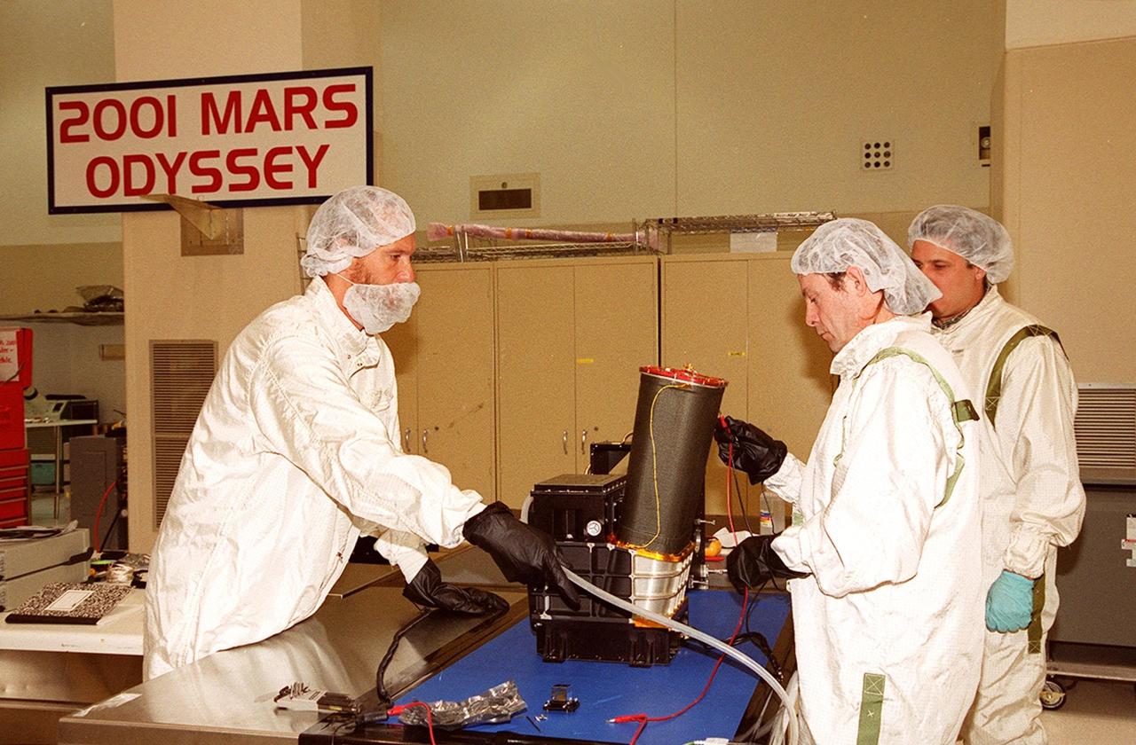 In the Spacecraft Assembly and Encapsulation Facility 2, workers test the Thermal Emission Imaging System (THEMIS) before attaching to the 2001 Mars Odyssey Orbiter. THEMIS will map the mineralogy and morphology of the Martian surface using a high-resolution camera and a thermal infrared imaging spectrometer. The orbiter will carry three science instruments: THEMIS, the Gamma Ray Spectrometer (GRS), and the Mars Radiation Environment Experiment (MARIE). The GRS will achieve global mapping of the elemental composition of the surface and determine the abundance of hydrogen in the shallow subsurface. The MARIE will characterize aspects of the near-space radiation environment with regards to the radiation-related risk to human explorers. The Mars Odyssey Orbiter is scheduled for launch on April 7, 2001, aboard a Delta 7925 rocket from Launch Pad 17-A, Cape Canaveral Air Force Station