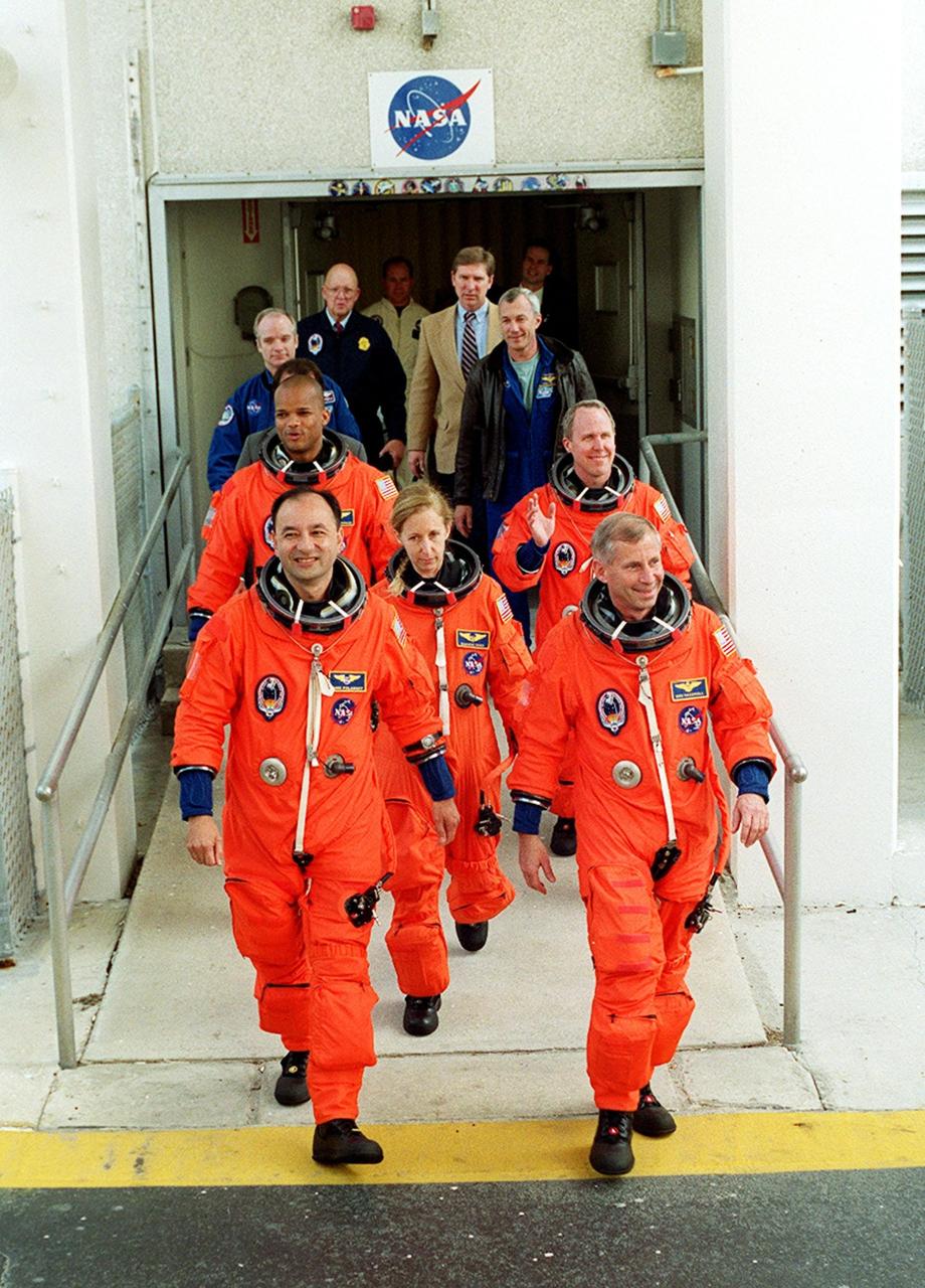 The STS-98 crew eagerly exits the Operations and Checkout Building to head for Space Shuttle Atlantis on Launch Pad 39A. Leading the crew are Pilot Mark Polansky (left) and Commander Ken Cockrell (right). In the center is Mission Specialist Marsha Ivins. Behind her are Mission Specialists Robert Curbeam (left) and Thomas Jones (right). They will be flying the seventh construction flight to the International Space Station. Atlantis is carrying the U.S. Laboratory Destiny, a key module in the growth of the Space Station. Destiny will be attached to the Unity node on the Space Station using the Shuttle’s robotic arm. Three spacewalks are required to complete the planned construction work during the 11-day mission. Launch is targeted for 6:11 p.m. EST and the planned landing at KSC Feb. 18 about 1:39 p.m. This mission marks the seventh Shuttle flight to the Space Station, the 23rd flight of Atlantis and the 102nd flight overall in NASA’s Space Shuttle program