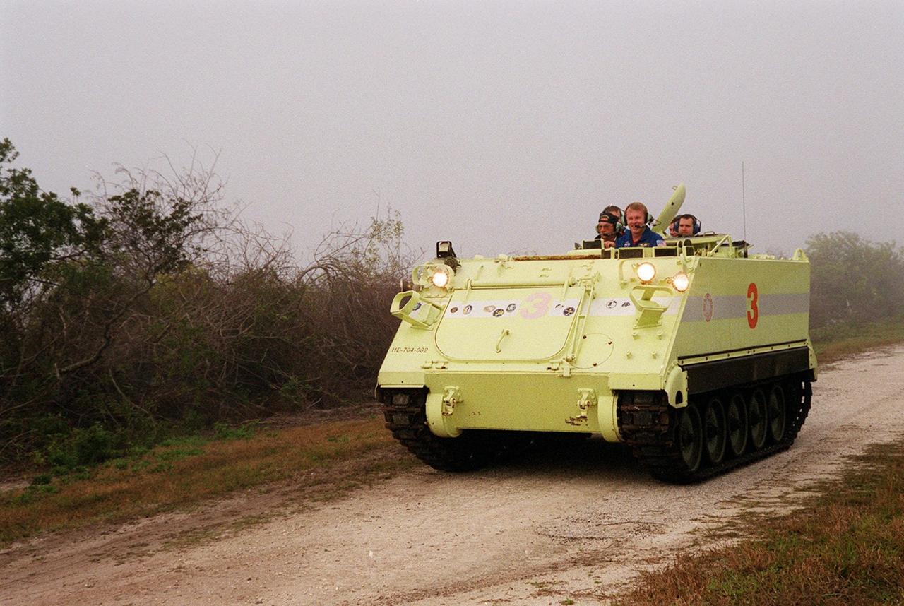 STS-102 Mission Specialist Andrew Thomas drives an M-113 armored carrier as part of emergency egress training. With him is (left) Capt. George Hoggard, a training officer with SGS Fire Services, and other crew members Commander James Wetherbee, Pilot James Kelly and Mission Specialist Paul Richards (seen behind Thomas, at right). The M-113, in the event of an emergency at the pad prior to launch, could be used to transport the crew to a nearby bunker or farther. The STS-102 crew is at KSC to take part in Terminal Countdown Demonstration Test activities, which also include a simulated launch countdown. STS-102 is the eighth construction flight to the International Space Station, carrying as payload the Multi-Purpose Logistics Module Leonardo. Launch on mission STS-102 is scheduled for March 8