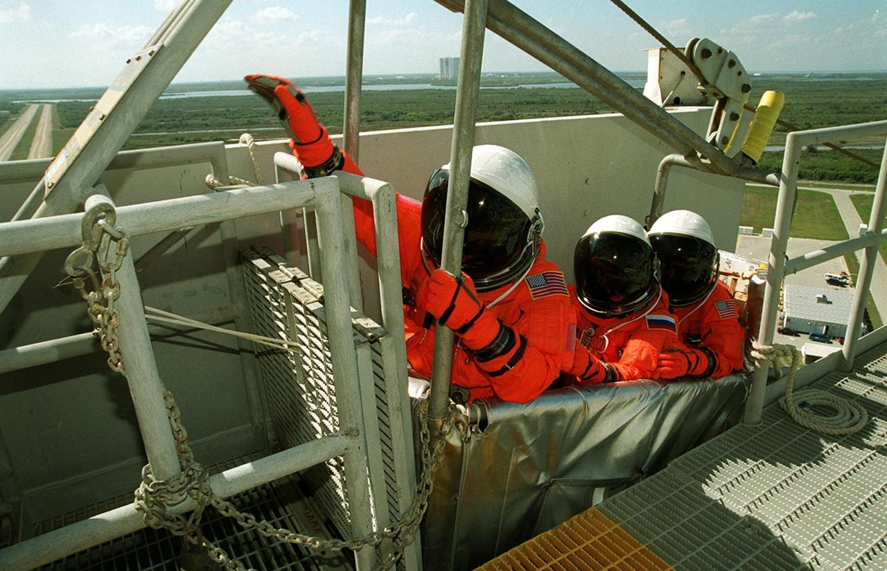An STS-102 crew member reaches for the release lever for the slidewire basket, used for emergency egress from the orbiter and pad. The crew is at KSC for Terminal Countdown Demonstration Test activities, which include the emergency training and a simulated launch countdown. On the horizon in the background can be seen the Vehicle Assembly Building. STS-102 is the eighth construction flight to the International Space Station, with Space Shuttle Discovery carrying the Multi-Purpose Logistics Module Leonardo. In addition, the Expedition Two crew will be on the mission, to replace Expedition One, who will return to Earth with Discovery. Launch on mission STS-102 is scheduled for March 8