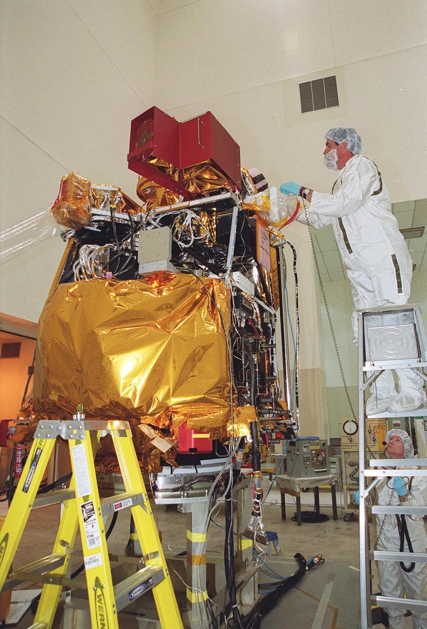 In the Spacecraft Assembly and Encapsulation Facility 2 (SAEF-2), workers prepare to remove the High Energy Neutron Detector (HEND), part of the Gamma Ray Spectrometer (GRS), from the 2001 Mars Odyssey Orbiter. The HEND was built by Russia’s Space Research Institute (IKI). The GRS will achieve global mapping of the elemental composition of the surface and determine the abundance of hydrogen in the shallow subsurface. The orbiter will carry two other science instruments: THEMIS and the Mars Radiation Environment Experiment (MARIE). THEMIS will map the mineralogy and morphology of the Martian surface using a high-resolution camera and a thermal infrared imaging spectrometer. The MARIE will characterize aspects of the near-space radiation environment with regards to the radiation-related risk to human explorers. The Mars Odyssey Orbiter is scheduled for launch April 7, 2001, aboard a Delta 7925 rocket from Launch Pad 17-A, Cape Canaveral Air Force Station