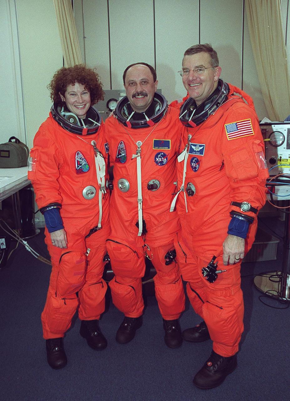 STS-102 Mission Specialists, Susan Helms, Yury Usachev and James Voss pose after suitup. Voss and Helms are making their fifth Shuttle flights and Usachev is making his second. All three are the Expedition Two crew who are replacing Expedition One on the International Space Station. STS-102 is the eighth construction flight to the Station, carrying the Multi-Purpose Logistics Module Leonardo. . The primary delivery system used to resupply and return Station cargo requiring a pressurized environment, Leonardo will deliver up to 10 tons of laboratory racks filled with equipment, experiments and supplies for outfitting the newly installed U.S. Laboratory Destiny. Discovery is set to launch March 8 at 6:42 a.m. EST. The 12-day mission is expected to end with a landing at KSC on March 20