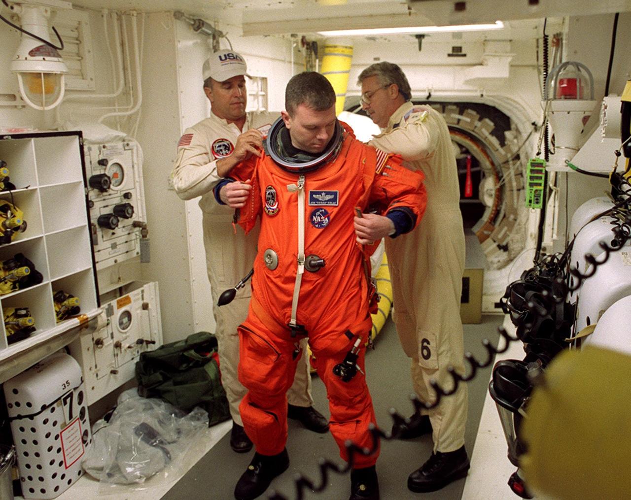 Before entering Space Shuttle Discovery, STS-102 Pilot James Kelly gets help with his launch and entry suit from technicians in the White Room. The mission is Kelly’s first Shuttle flight. Discovery is carrying the Multi-Purpose Logistics Module Leonardo on the eighth construction flight to the International Space Station. The primary delivery system used to resupply and return Station cargo requiring a pressurized environment, Leonardo will deliver up to 10 tons of laboratory racks filled with equipment, experiments and supplies for outfitting the newly installed U.S. Laboratory Destiny. Discovery is set to launch March 8 at 6:42 a.m. EST. The 12-day mission is expected to end with a landing at KSC on March 20