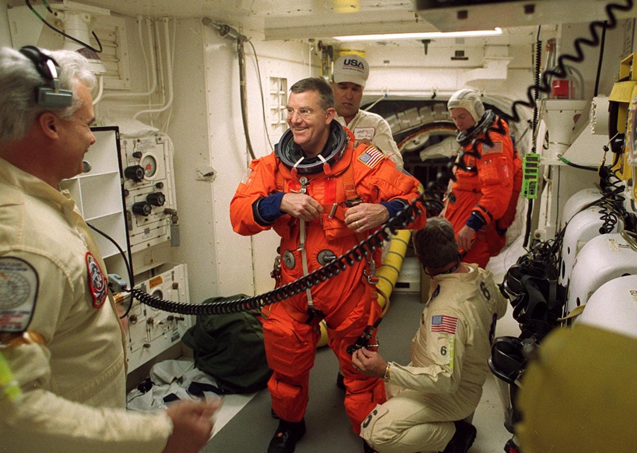 Before entering Space Shuttle Discovery, STS-102 Mission Specialist James Voss (center) is helped preparing his launch and entry suit for launch from technicians in the White Room. The mission is Voss’s fifth Shuttle flight. In the background is Pilot James Kelly waiting to enter Discovery. Voss is also part of the Expedition Two crew flying on the mission to replace the Expedition One crew on the Station. Discovery is carrying the Multi-Purpose Logistics Module Leonardo on the eighth construction flight to the International Space Station. The primary delivery system used to resupply and return Station cargo requiring a pressurized environment, Leonardo will deliver up to 10 tons of laboratory racks filled with equipment, experiments and supplies for outfitting the newly installed U.S. Laboratory Destiny. Discovery is set to launch March 8 at 6:42 a.m. EST. The 12-day mission is expected to end with a landing at KSC on March 20