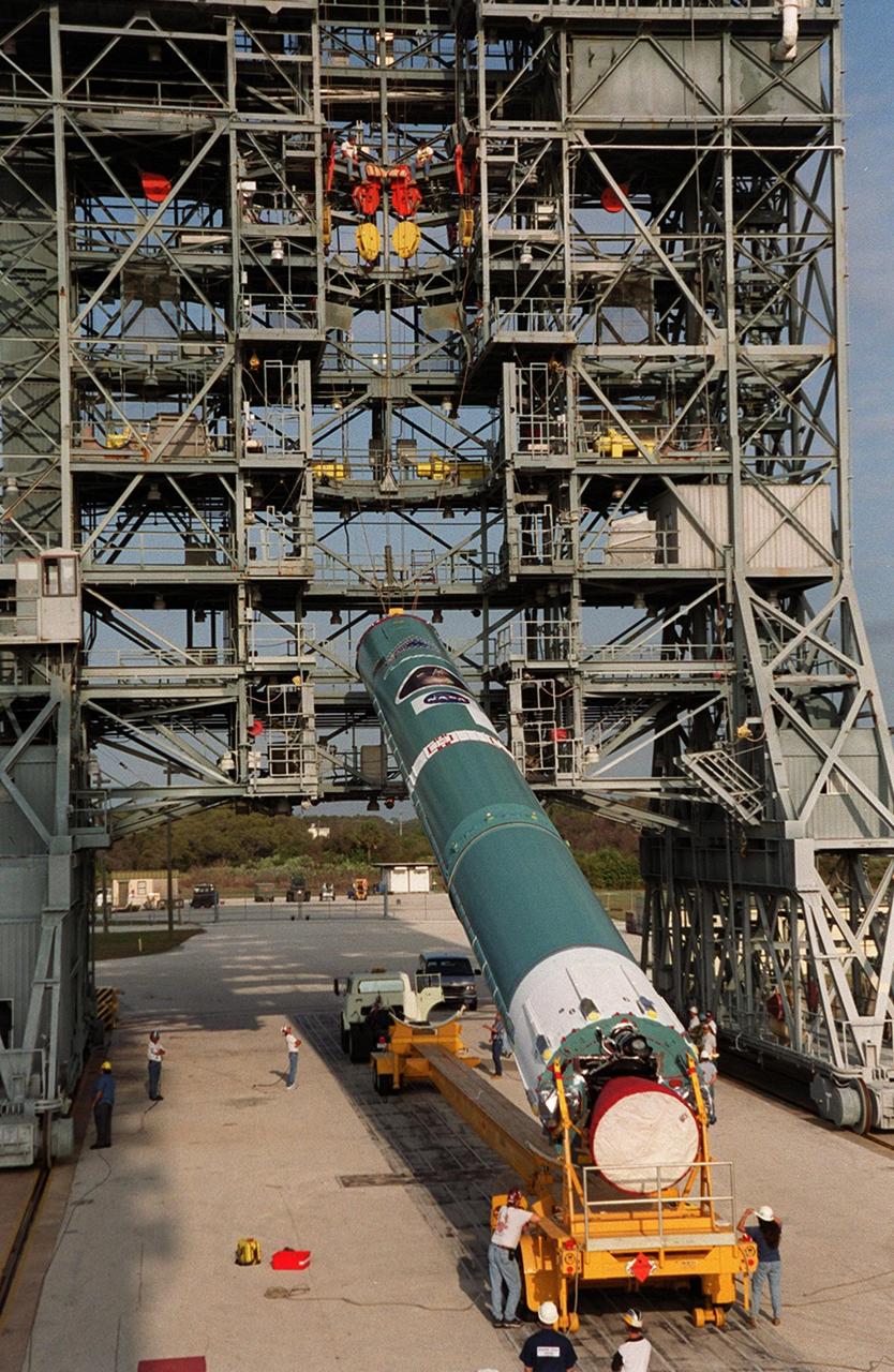 Cranes on the gantry on Launch Pad 17-A, Cape Canaveral Air Force Station, lift the first stage of a Boeing Delta rocket to a vertical position. The rocket will carry the 2001 Mars Odyssey Orbiter, scheduled for launch April 7, 2001. Mars Odyssey contains three science instruments: THEMIS, the Gamma Ray Spectrometer (GRS), and the Mars Radiation Environment Experiment (MARIE). THEMIS will map the mineralogy and morphology of the Martian surface using a high-resolution camera and a thermal infrared imaging spectrometer. The GRS will achieve global mapping of the elemental composition of the surface and determine the abundance of hydrogen in the shallow subsurface. The MARIE will characterize aspects of the near-space radiation environment with regards to the radiation-related risk to human explorers