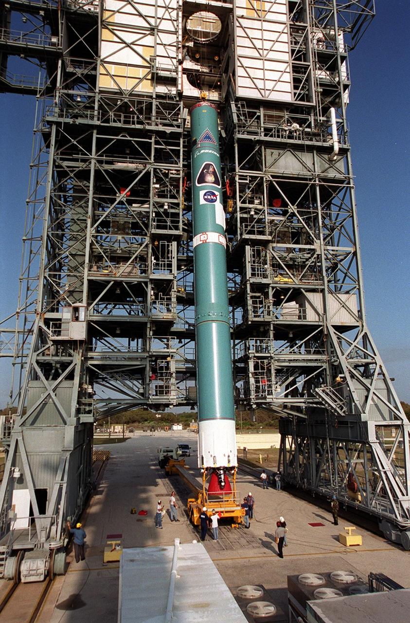 The first stage of a Boeing Delta rocket is eased into a vertical position to be lifted up the gantry on Launch Pad 17-A, Cape Canaveral Air Force Station. The rocket will carry the 2001 Mars Odyssey Orbiter, scheduled for launch April 7, 2001. Mars Odyssey contains three science instruments: THEMIS, the Gamma Ray Spectrometer (GRS), and the Mars Radiation Environment Experiment (MARIE). THEMIS will map the mineralogy and morphology of the Martian surface using a high-resolution camera and a thermal infrared imaging spectrometer. The GRS will achieve global mapping of the elemental composition of the surface and determine the abundance of hydrogen in the shallow subsurface. The MARIE will characterize aspects of the near-space radiation environment with regards to the radiation-related risk to human explorers