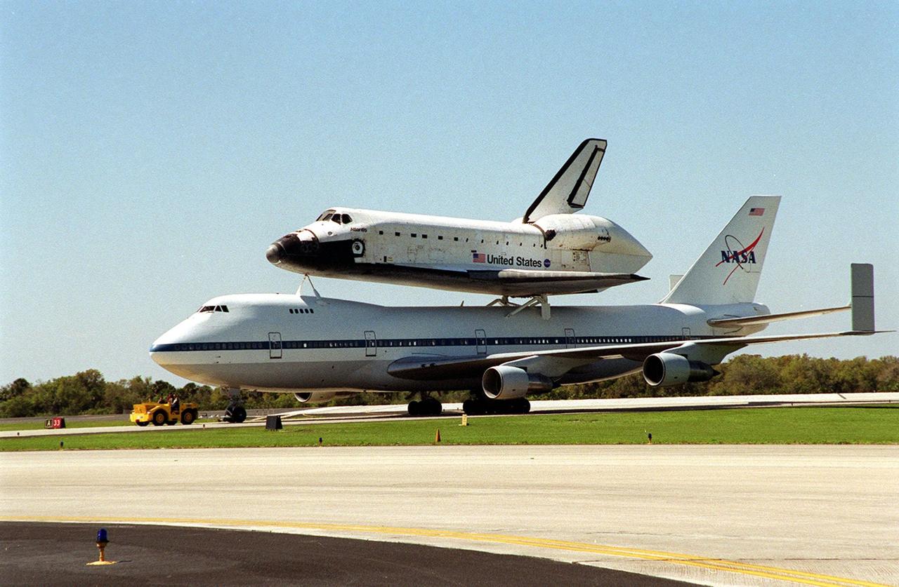 The Shuttle Carrier Aircraft, with its piggyback cargo the orbiter Atlantis, turns on the runway after landing at the KSC Shuttle Landing Facility. The ground vehicle near the nose will tow it to the mate/demate device to have Atlantis removed from its perch. Atlantis landed in California Feb. 19 concluding mission STS-98. The ferry flight began in California March 1; unfavorable weather conditions kept it on the ground at Altus AFB, Okla., until it could return to Florida. The orbiter will next fly on mission STS-104, the 10th construction flight to the International Space Station, scheduled June 8