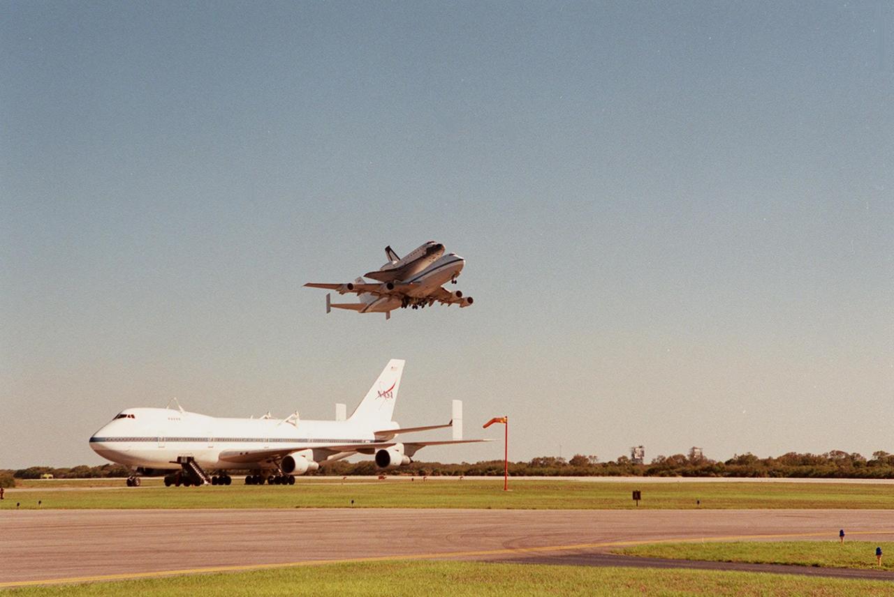 The Shuttle Carrier Aircraft with orbiter Columbia on top takes off from the Cape Canaveral Air Force Station Skid Strip. In the foreground is another SCA, which brought Atlantis back to KSC from California. The ferry flight began in California March 1. Unfavorable weather conditions kept it on the ground at Dyess AFB, Texas, until it could return to Florida. Columbia is returning from a 17-month-long modification and refurbishment process as part of a routine maintenance plan. The orbiter will next fly on mission STS-107, scheduled Oct. 25